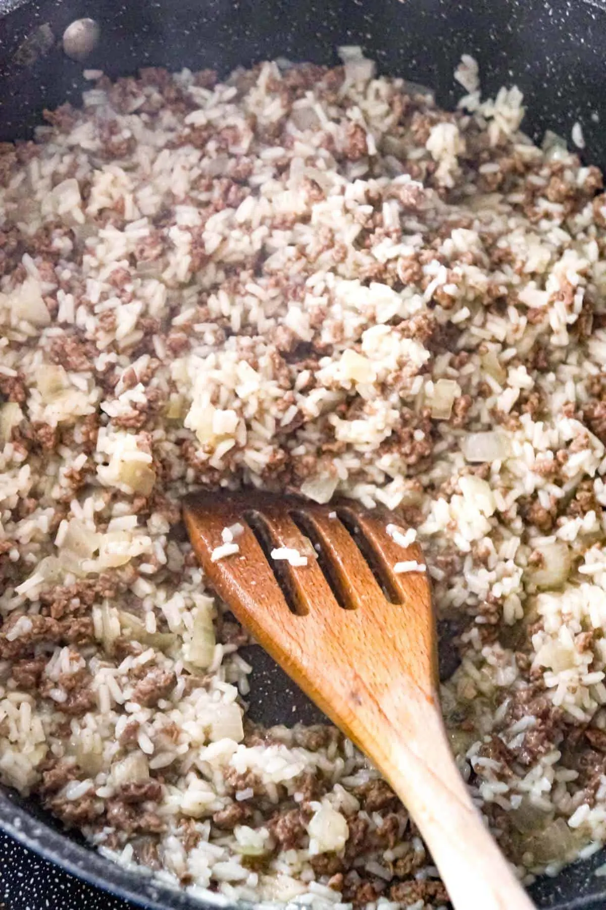 cooked ground beef and rice in a pan