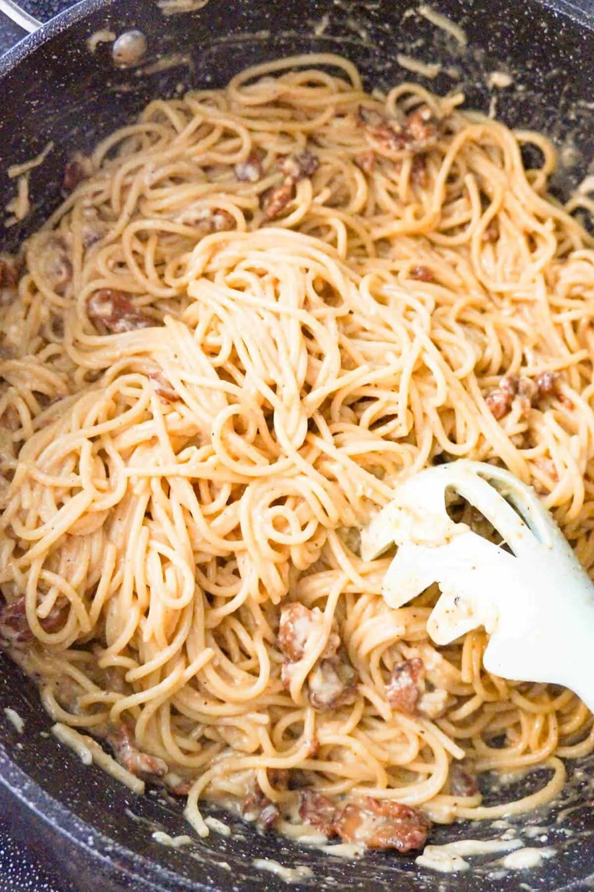 stirring spaghetti carbonara