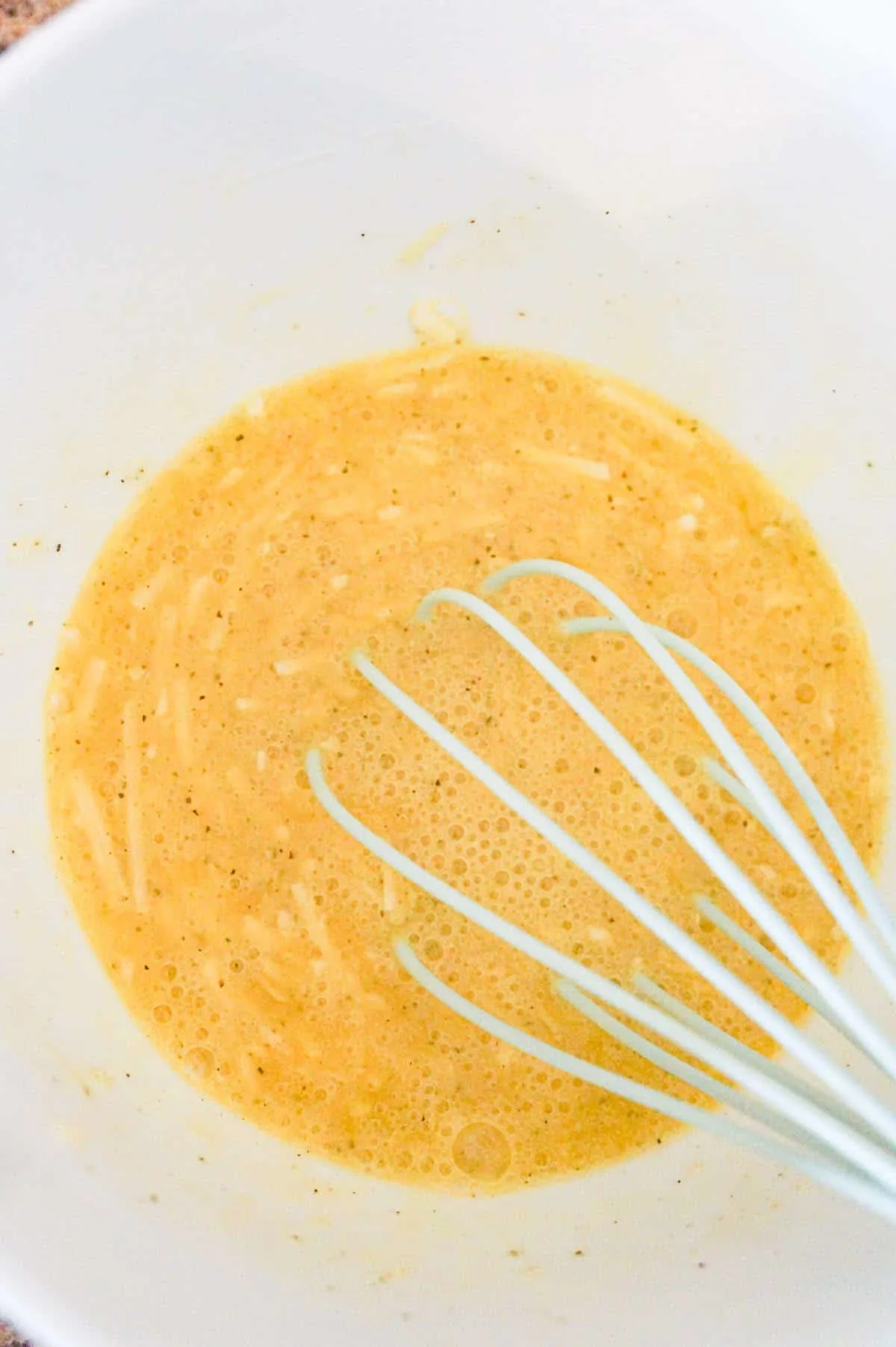 whisked egg and Parmesan cheese mixture in a bowl