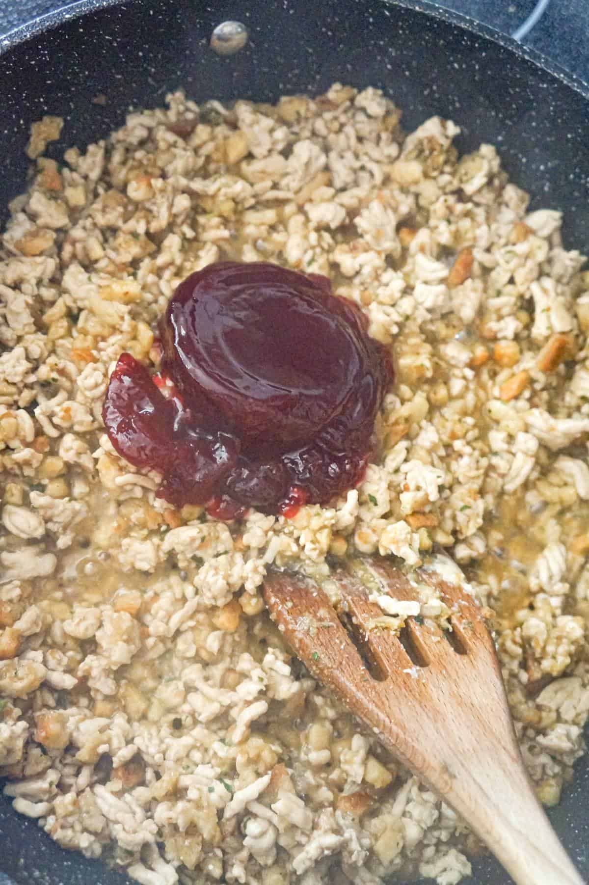 canned cranberry sauce on top of ground turkey sloppy joe mixture in a saute pan