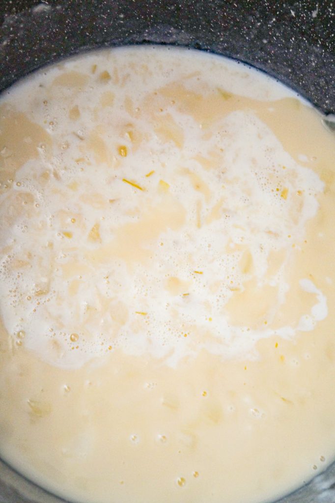 milk added to chicken broth and flour mixture in a large pot