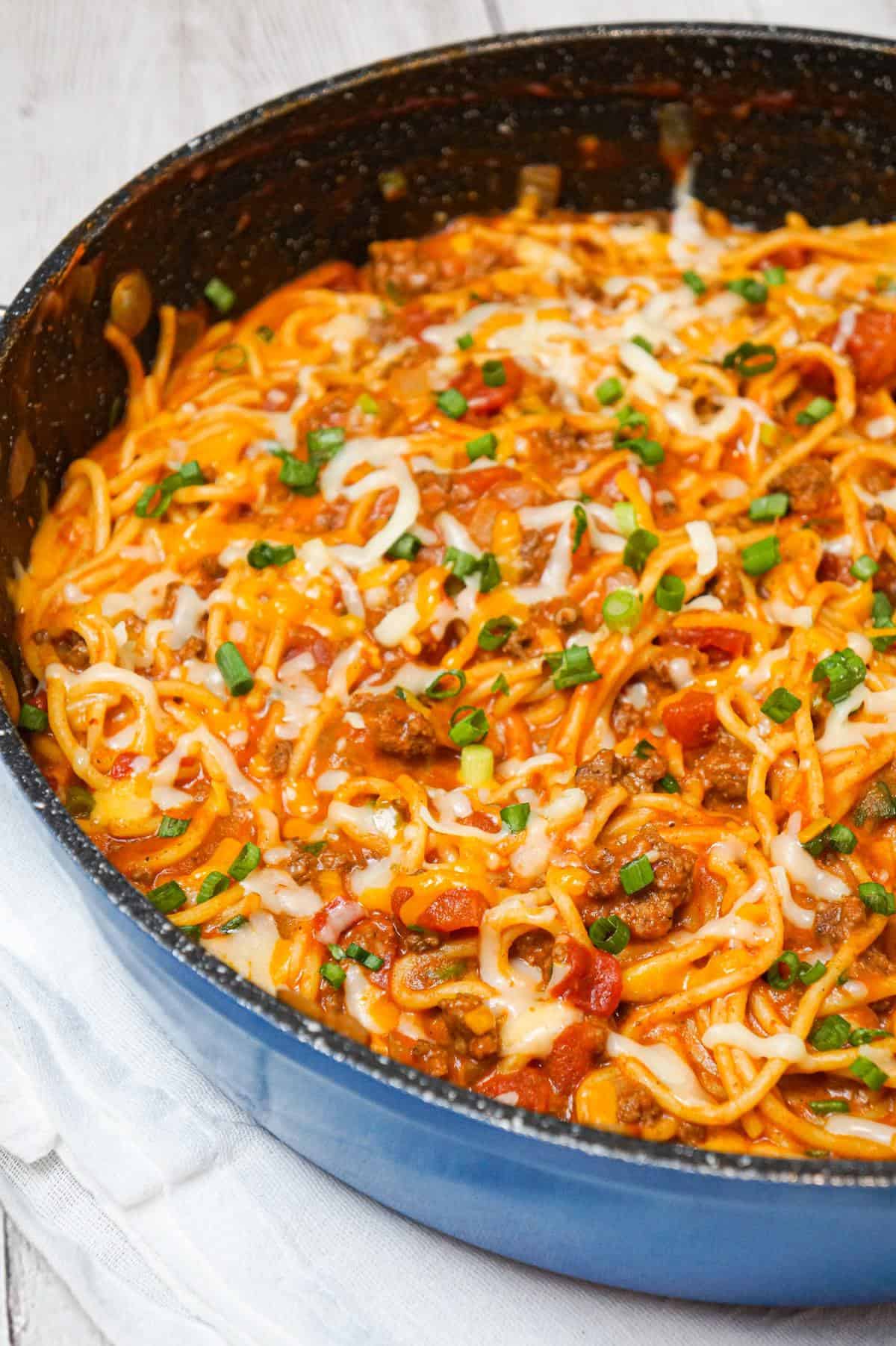 Cheesy Taco Spaghetti is an easy weeknight dinner recipe loaded with ground beef, Rotel diced tomatoes and chilies, green onions and shredded cheese all tossed in taco seasoning and tomato sauce.