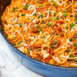 Cheesy Taco Spaghetti is an easy weeknight dinner recipe loaded with ground beef, Rotel diced tomatoes and chilies, green onions and shredded cheese all tossed in taco seasoning and tomato sauce.