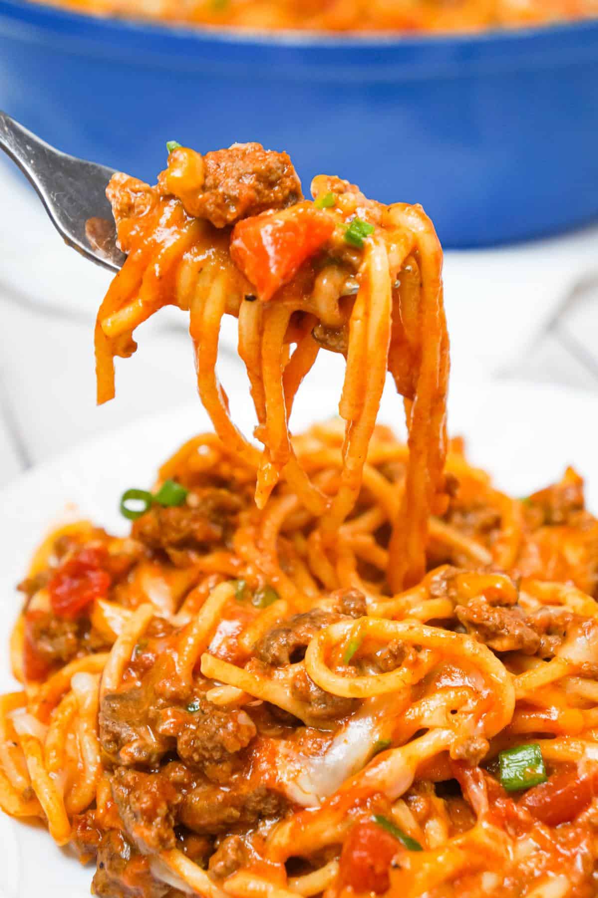 Cheesy Taco Spaghetti is an easy weeknight dinner recipe loaded with ground beef, Rotel diced tomatoes and chilies, green onions and shredded cheese all tossed in taco seasoning and tomato sauce.