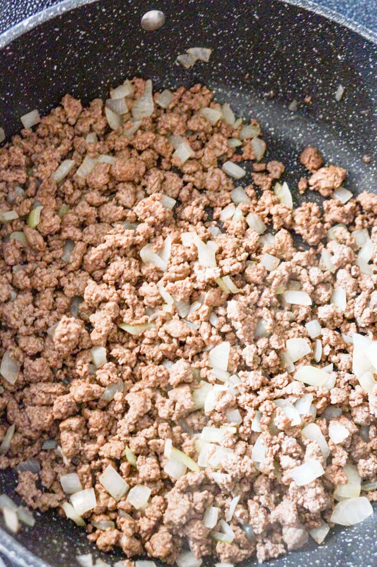 cooked ground beef and diced onions in a saute pan