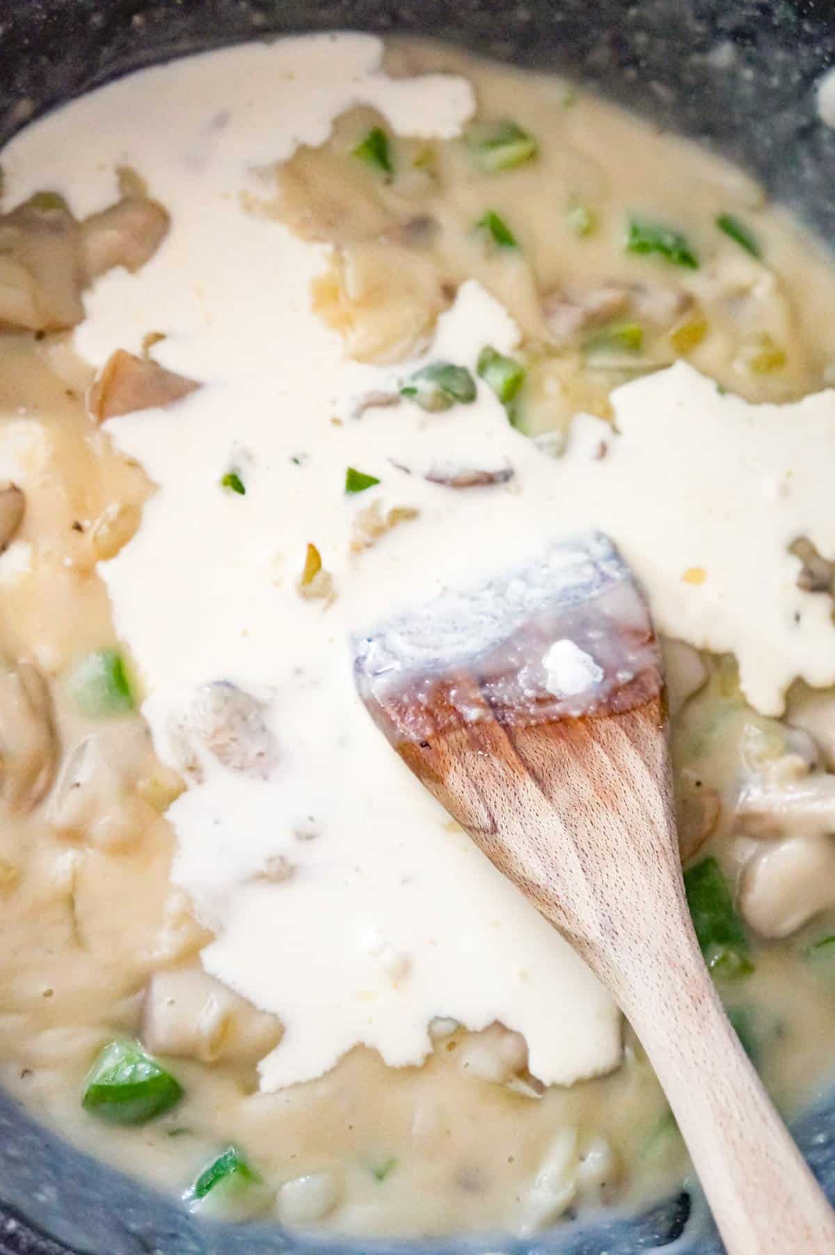 heavy cream on top of thickened broth mixture in a saute pan