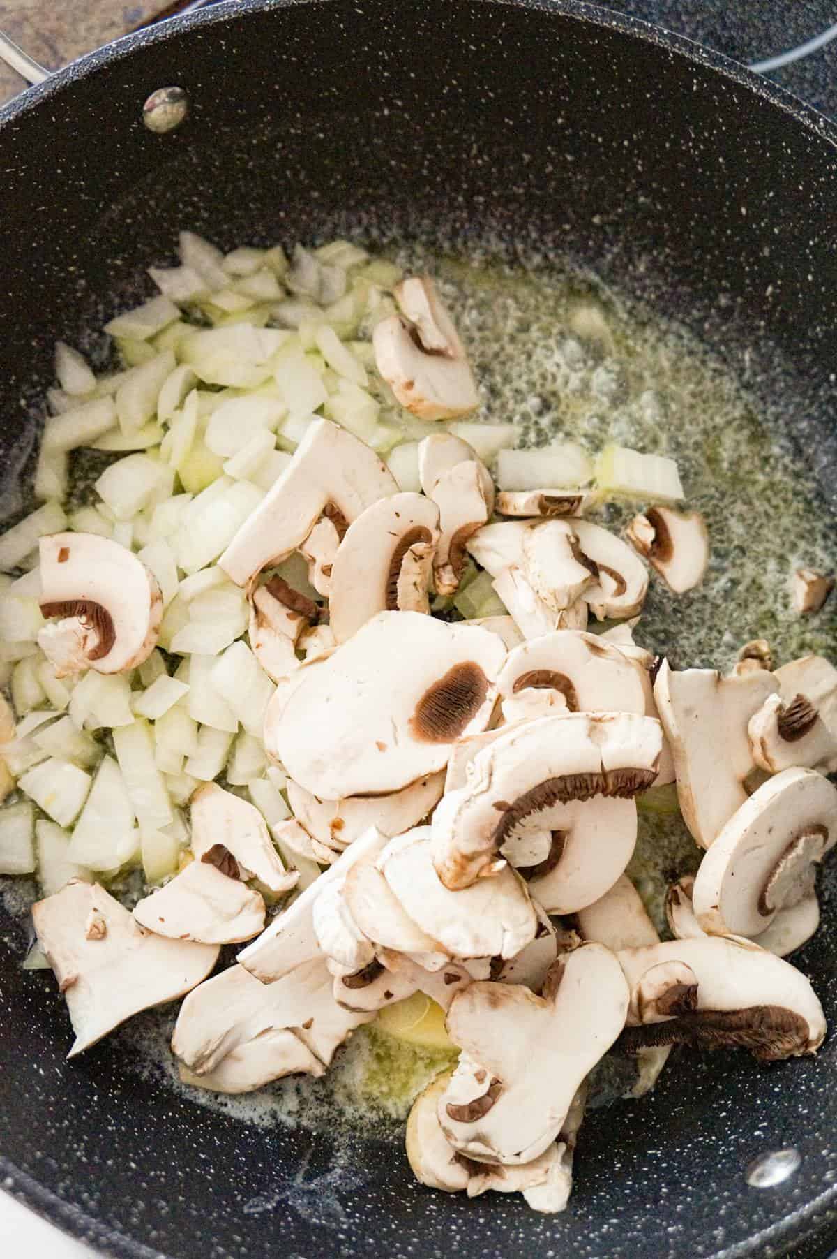 sliced mushrooms and diced onions added to a pan with melted butter