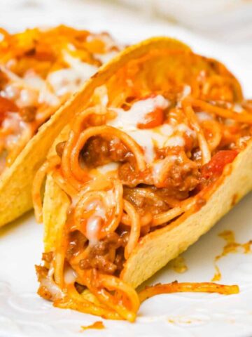 Spaghetti Tacos are an easy dinner recipe made with stand and stuff taco shells loaded with spaghetti and ground beef tossed in in tomato sauce with taco seasoning and baked with cheese.