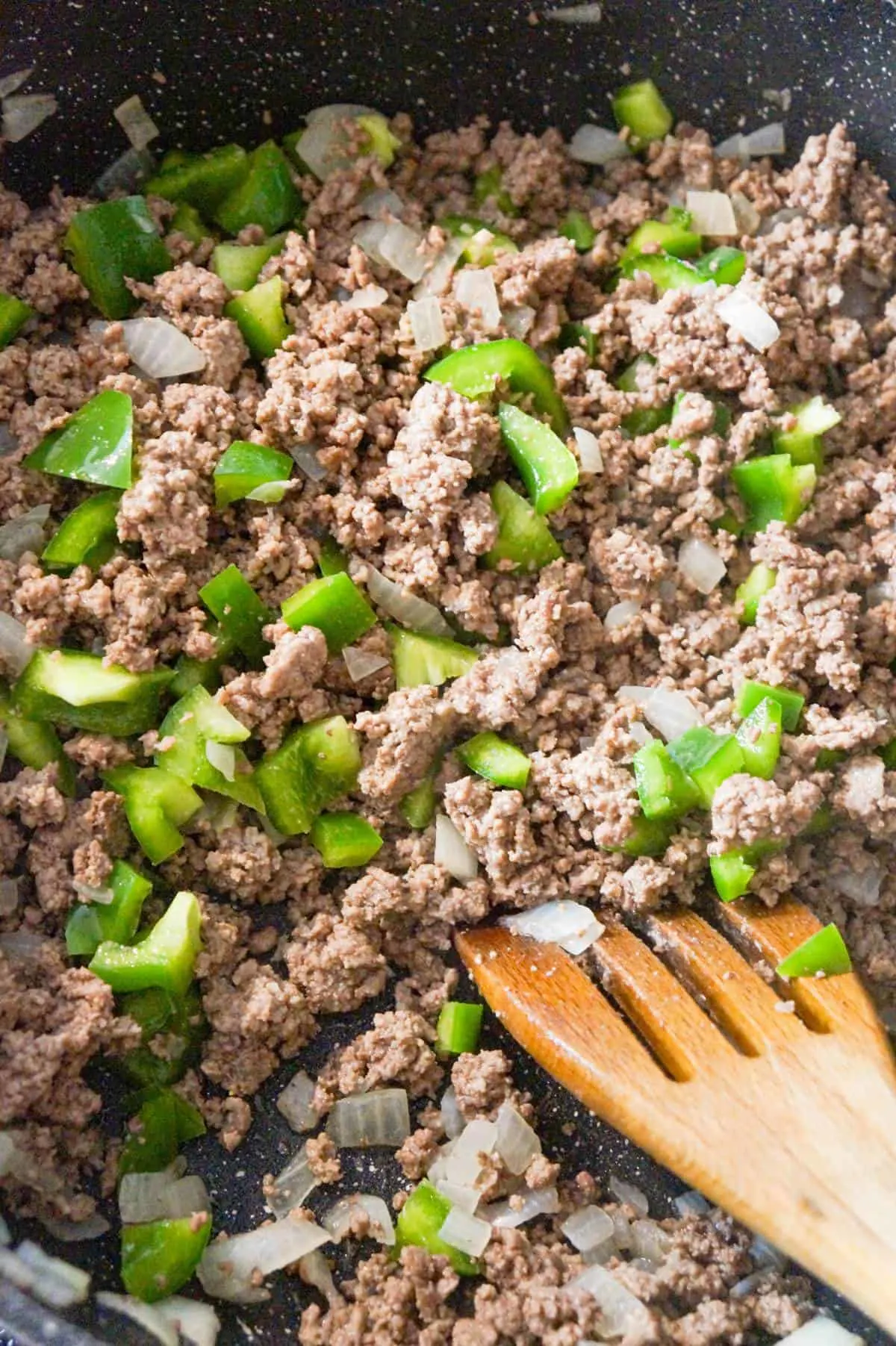 cooked ground beef and diced green peppers in a saute pan