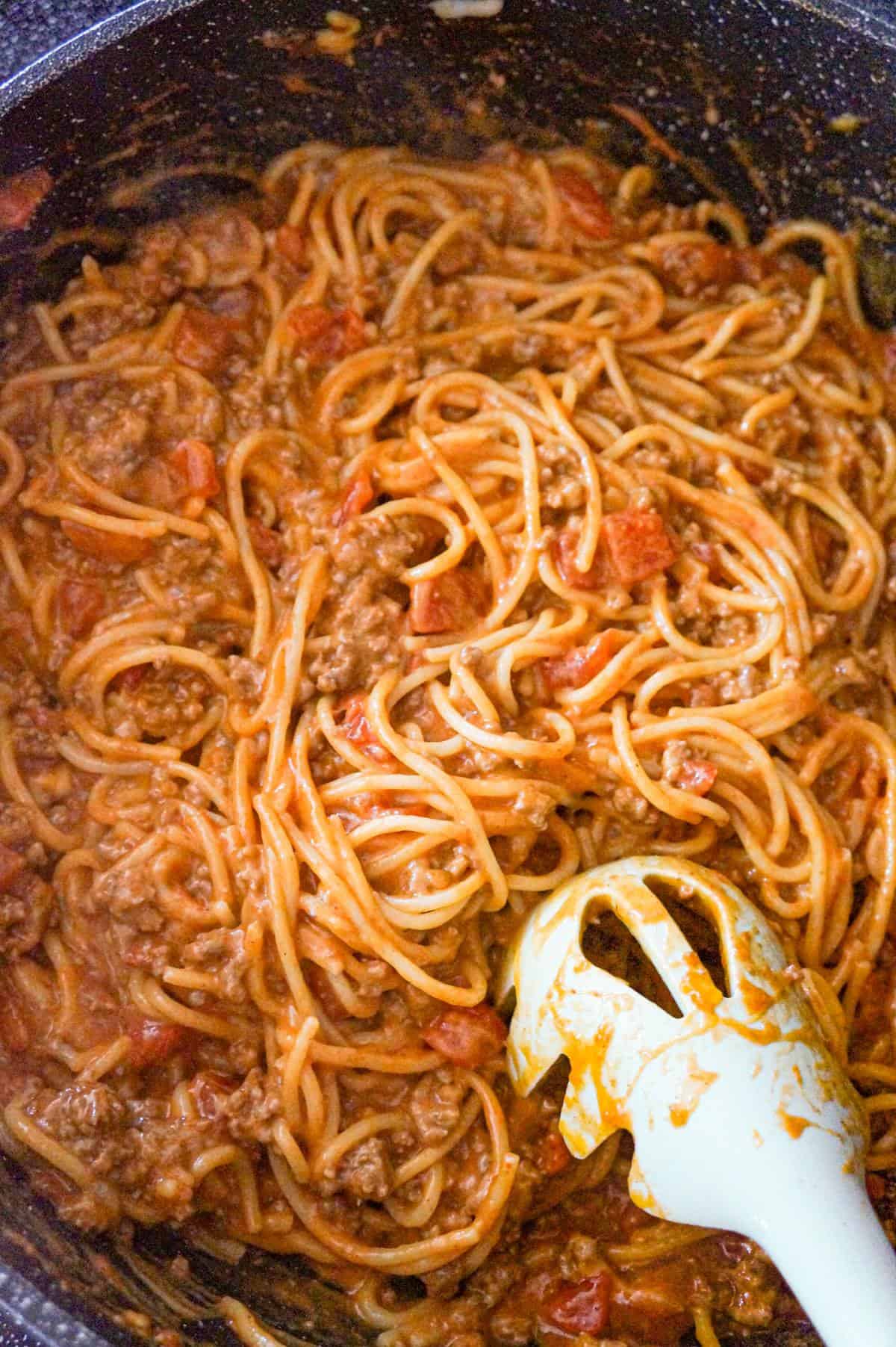 cheesy spaghetti with ground beef in a saute pan