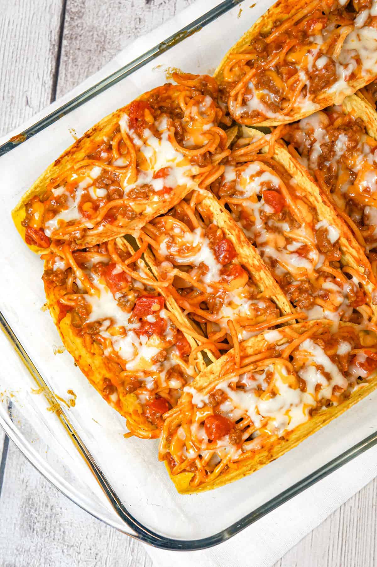 Spaghetti Tacos are an easy dinner recipe made with stand and stuff taco shells loaded with spaghetti and ground beef tossed in in tomato sauce with taco seasoning and baked with cheese.