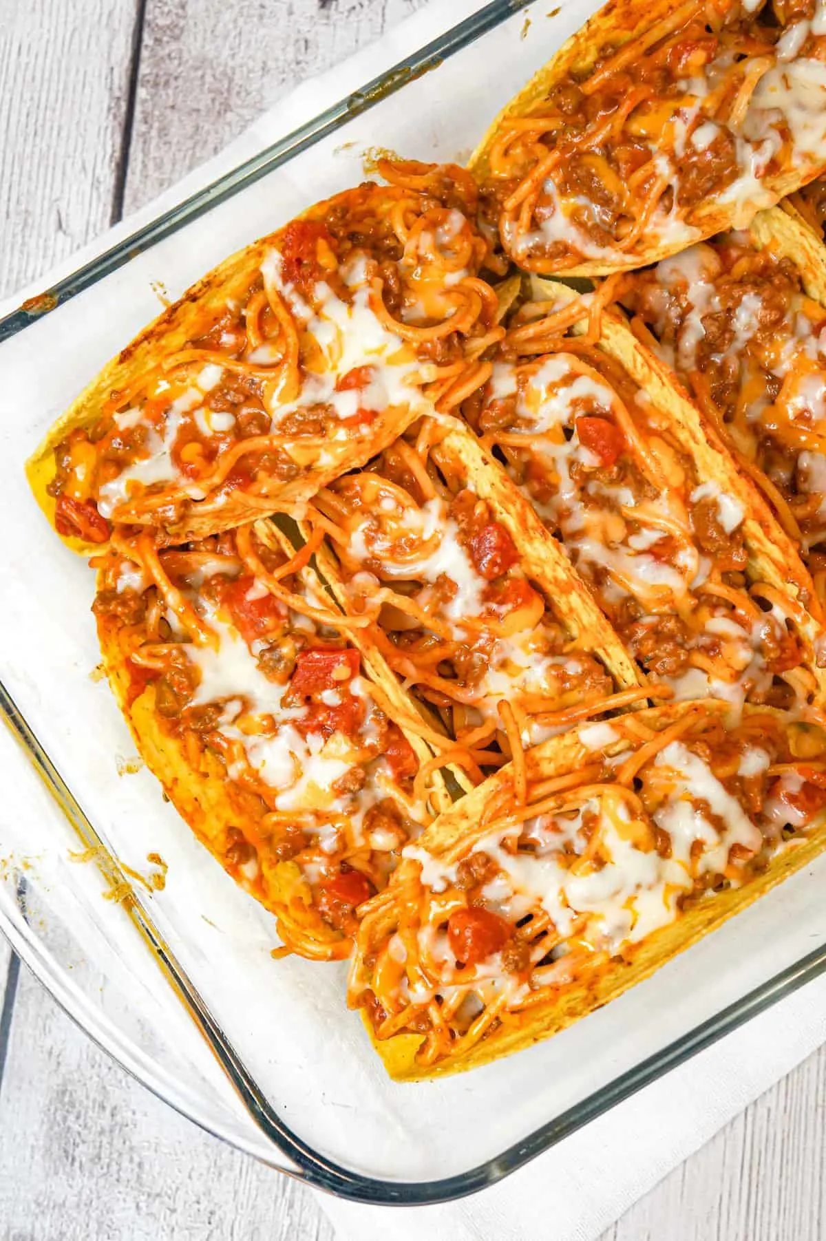 Spaghetti Tacos are an easy dinner recipe made with stand and stuff taco shells loaded with spaghetti and ground beef tossed in in tomato sauce with taco seasoning and baked with cheese.