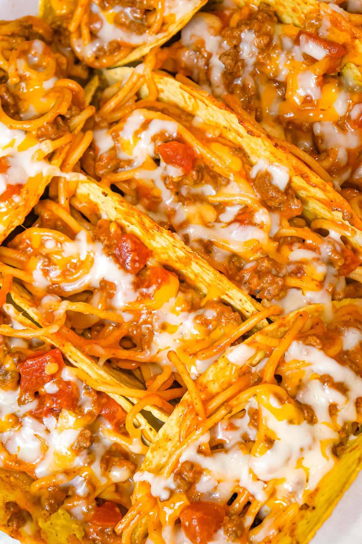 Spaghetti Tacos are an easy dinner recipe made with stand and stuff taco shells loaded with spaghetti and ground beef tossed in in tomato sauce with taco seasoning and baked with cheese.