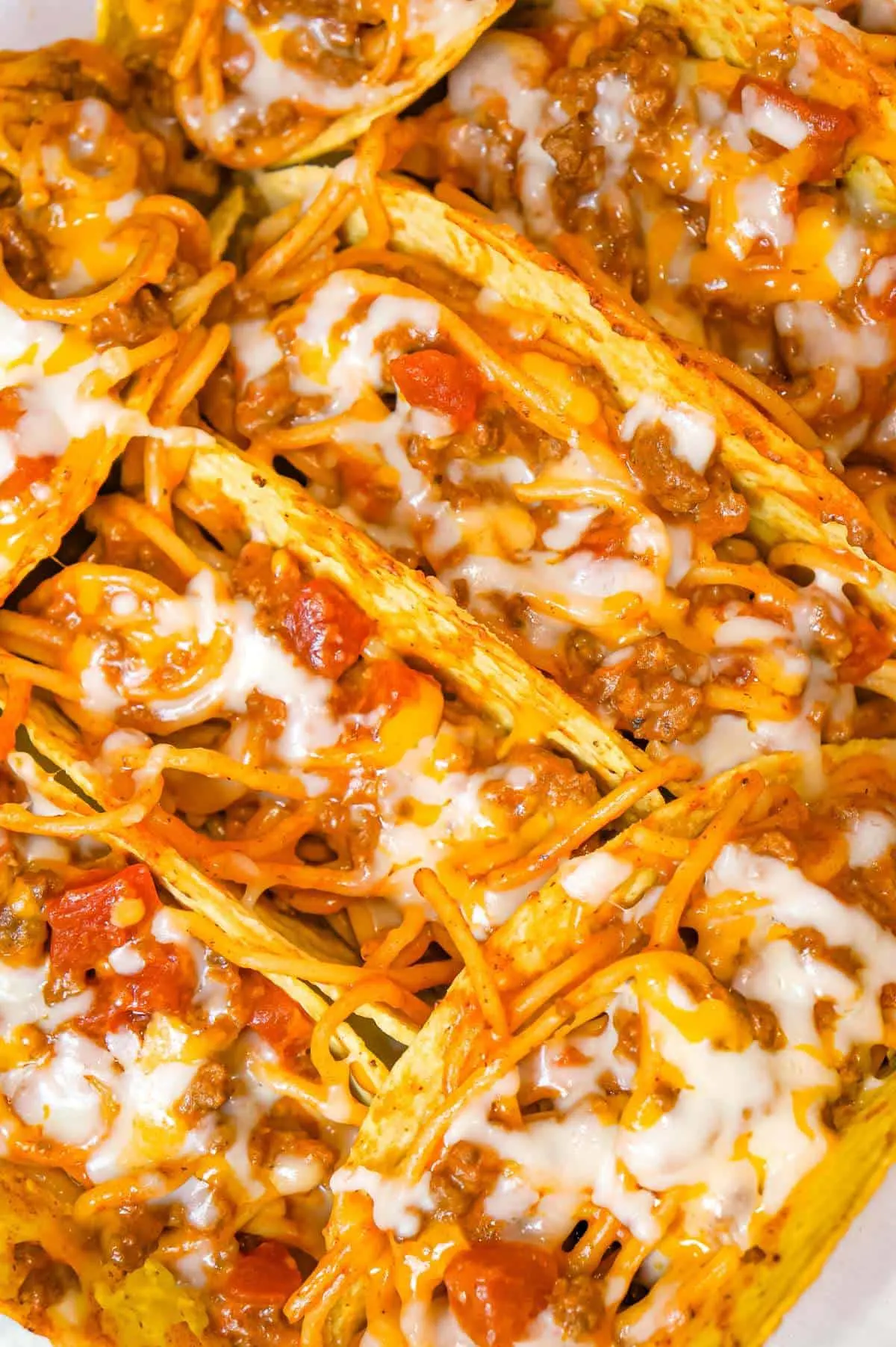 Spaghetti Tacos are an easy dinner recipe made with stand and stuff taco shells loaded with spaghetti and ground beef tossed in in tomato sauce with taco seasoning and baked with cheese.