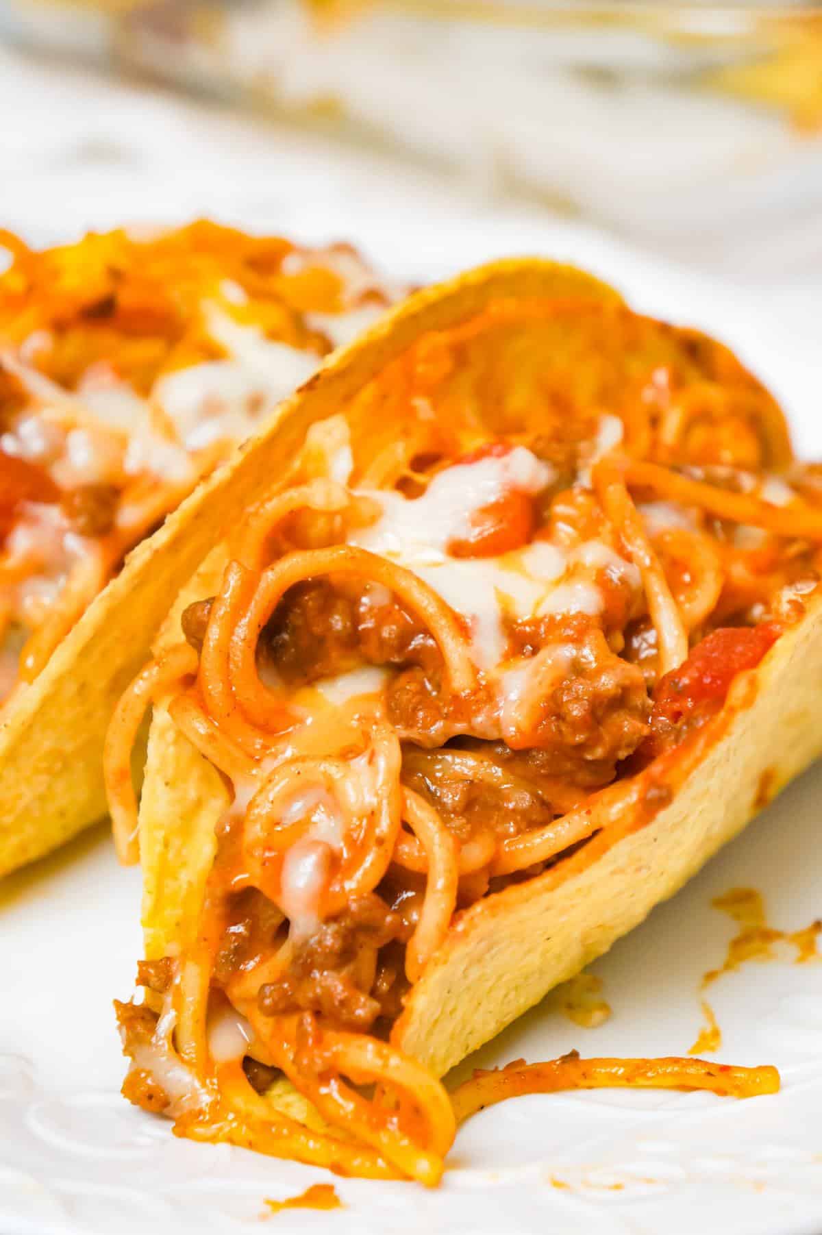 Spaghetti Tacos are an easy dinner recipe made with stand and stuff taco shells loaded with spaghetti and ground beef tossed in in tomato sauce with taco seasoning and baked with cheese.