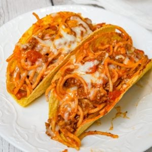 Spaghetti Tacos are an easy dinner recipe made with stand and stuff taco shells loaded with spaghetti and ground beef tossed in in tomato sauce with taco seasoning and baked with cheese.