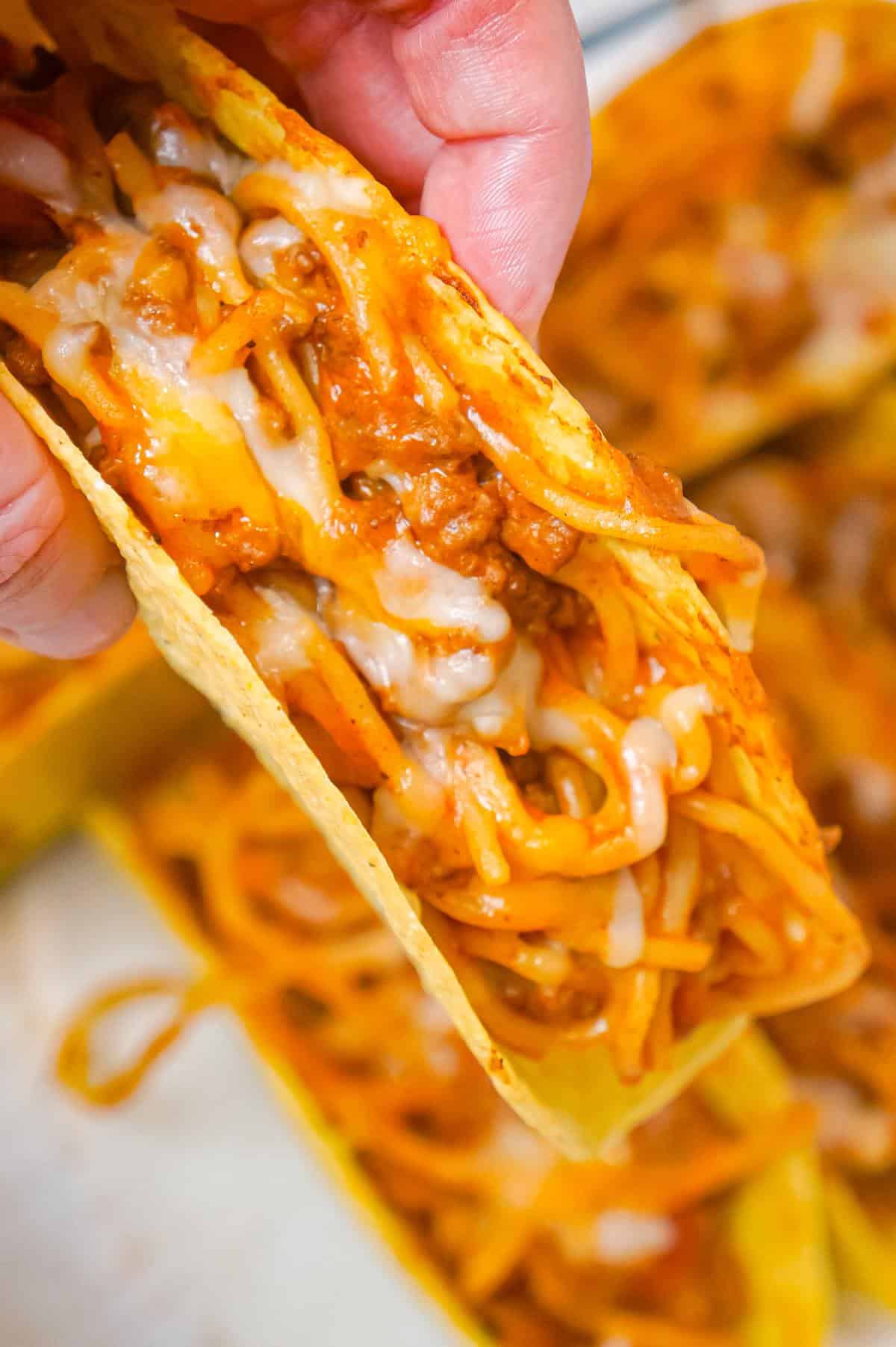 Spaghetti Tacos are an easy dinner recipe made with stand and stuff taco shells loaded with spaghetti and ground beef tossed in in tomato sauce with taco seasoning and baked with cheese.