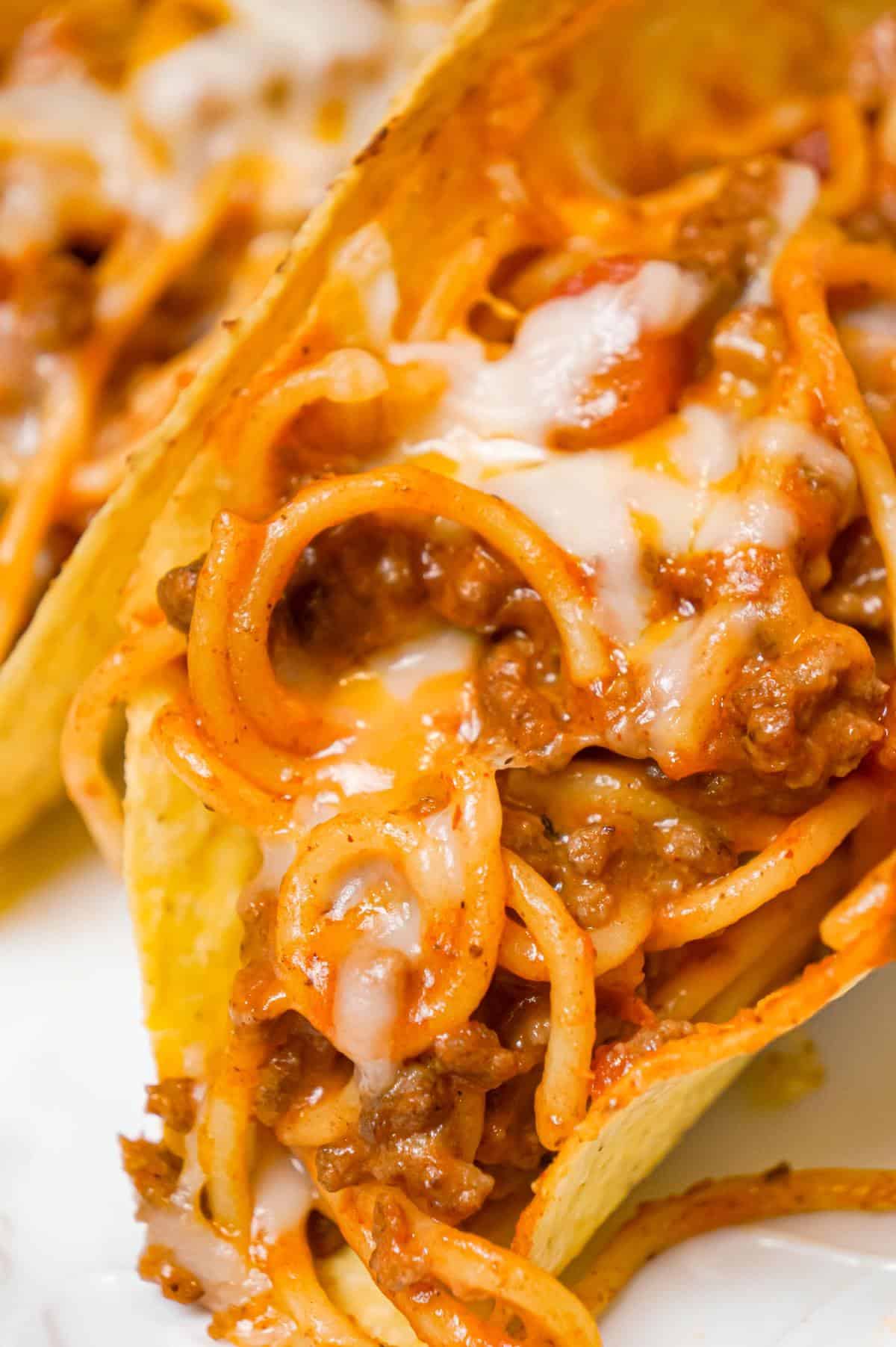 Spaghetti Tacos are an easy dinner recipe made with stand and stuff taco shells loaded with spaghetti and ground beef tossed in in tomato sauce with taco seasoning and baked with cheese.