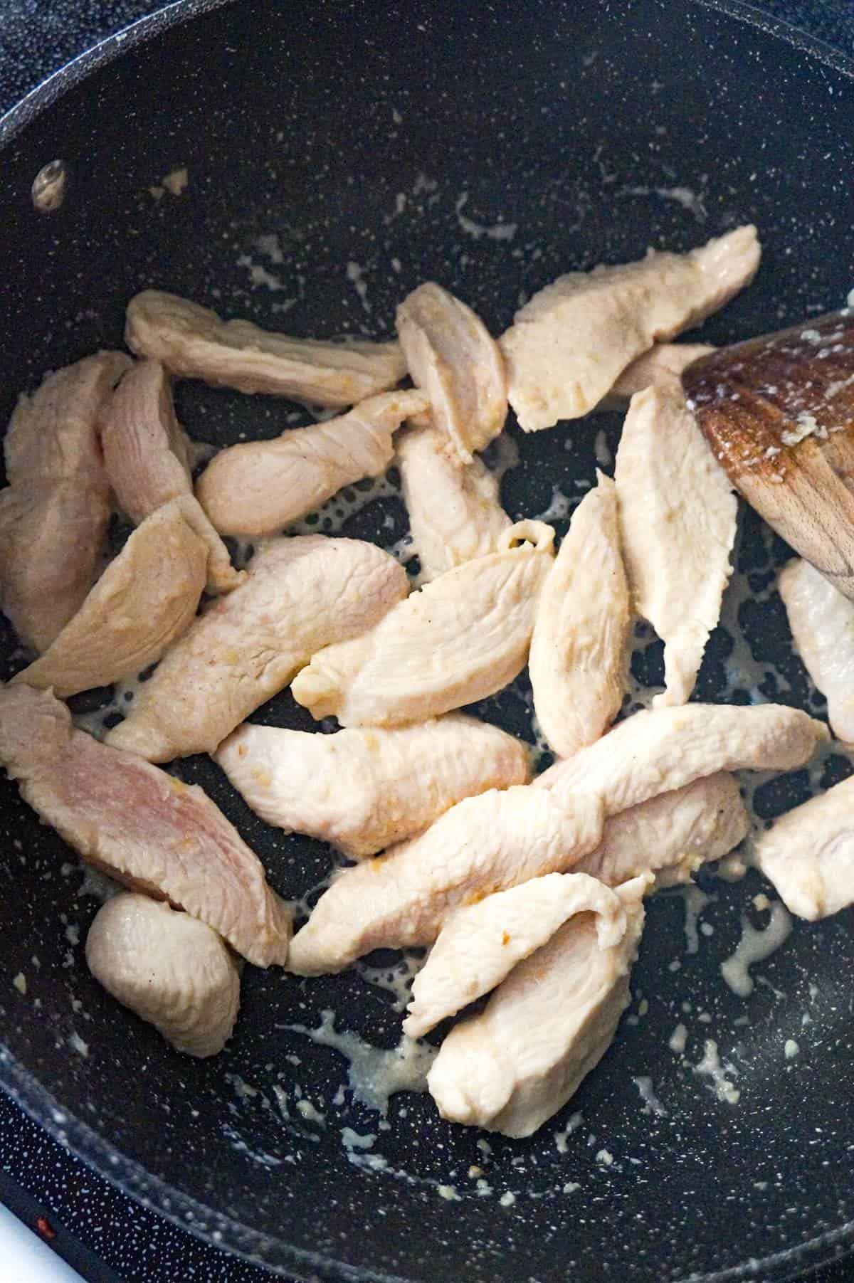 chicken breast strips cooking in a saute pan