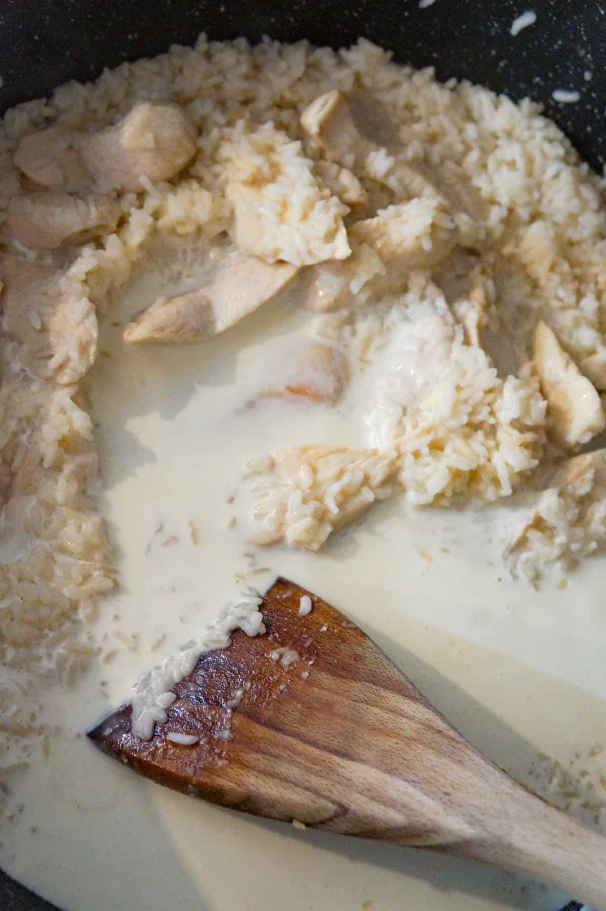 heavy cream added to chicken and rice in a saute pan