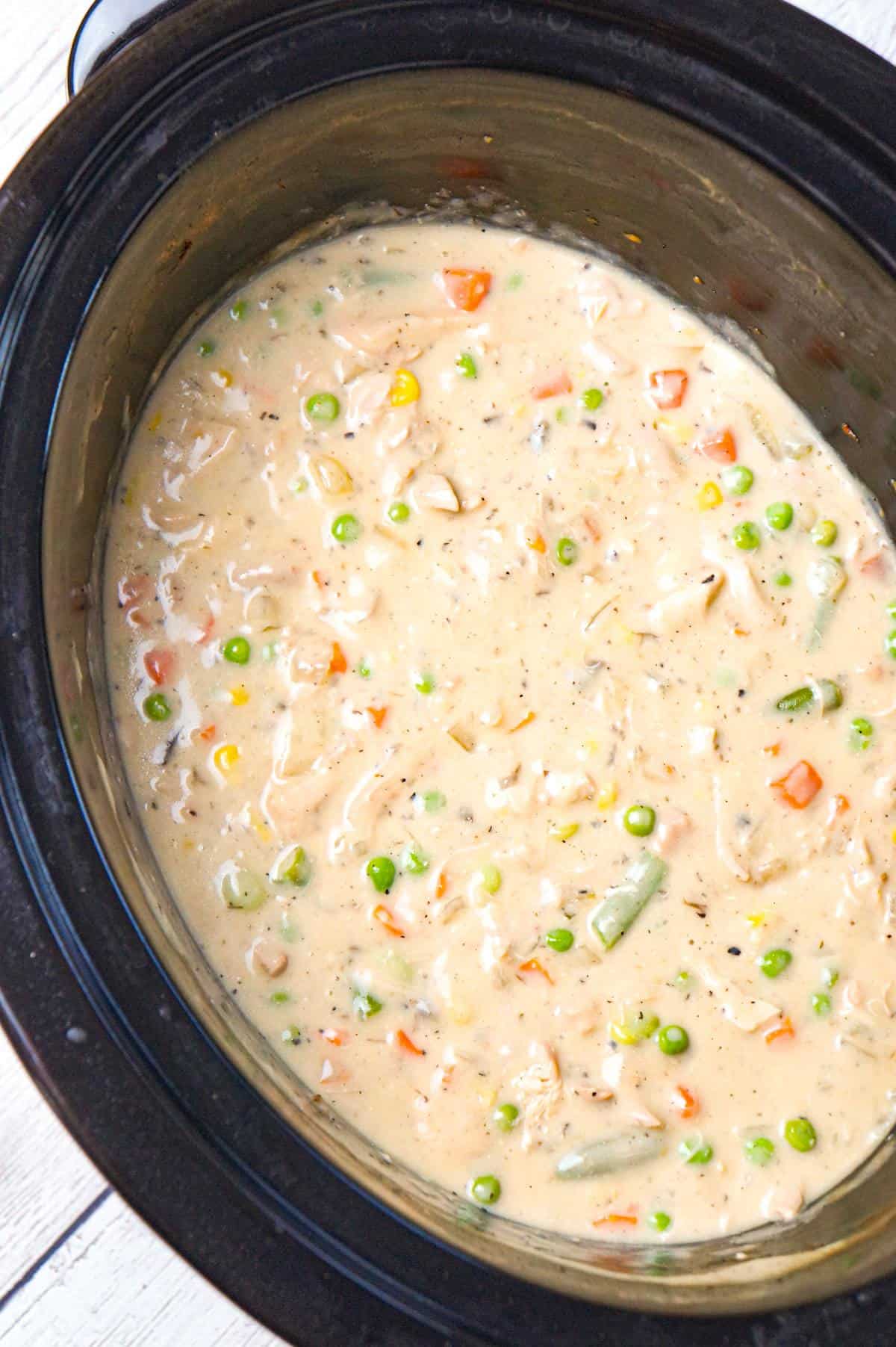 Crock Pot Chicken Pot Pie is an easy slow cooker dinner recipe made with boneless, skinless chicken thighs, cream of mushroom soup, cream of chicken soup and mixed veggies and topped with Pillsbury biscuits.