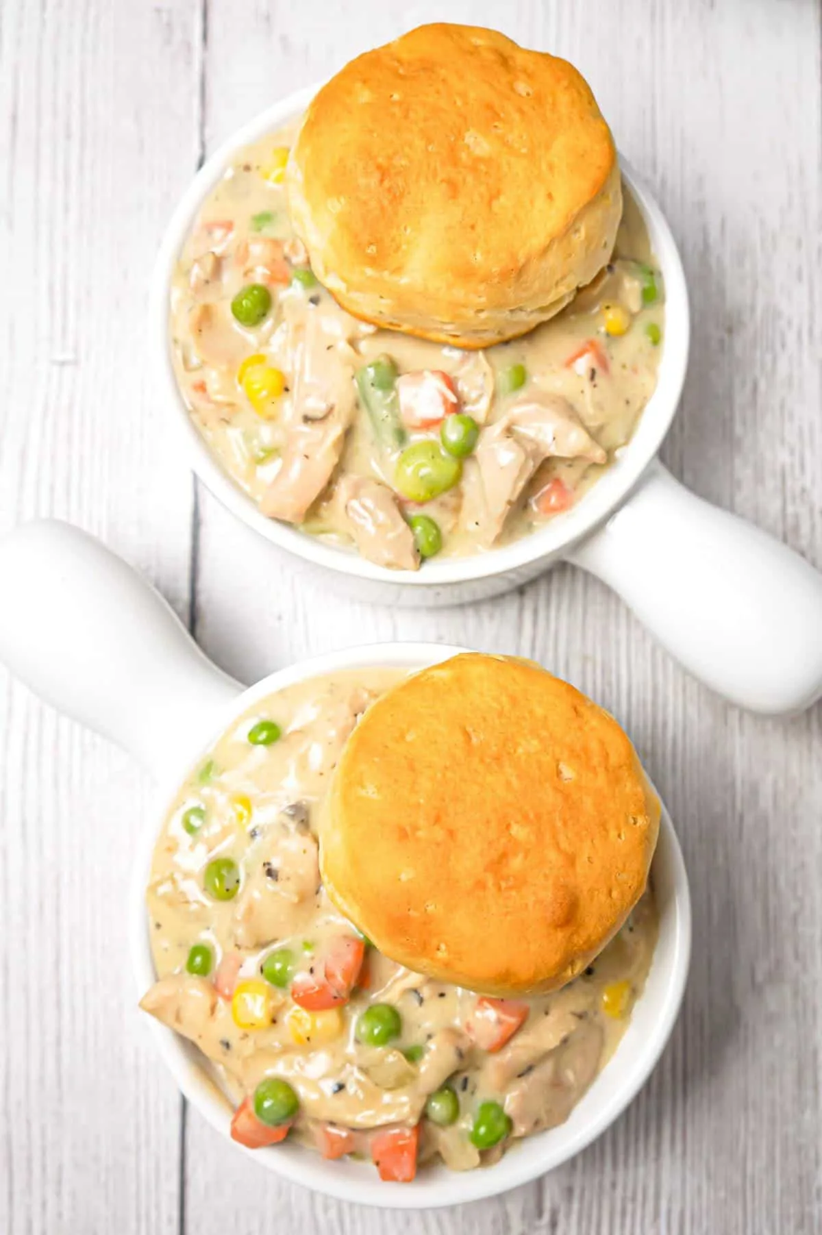 Crock Pot Chicken Pot Pie is an easy slow cooker dinner recipe made with boneless, skinless chicken thighs, cream of mushroom soup, cream of chicken soup and mixed veggies and topped with Pillsbury biscuits.