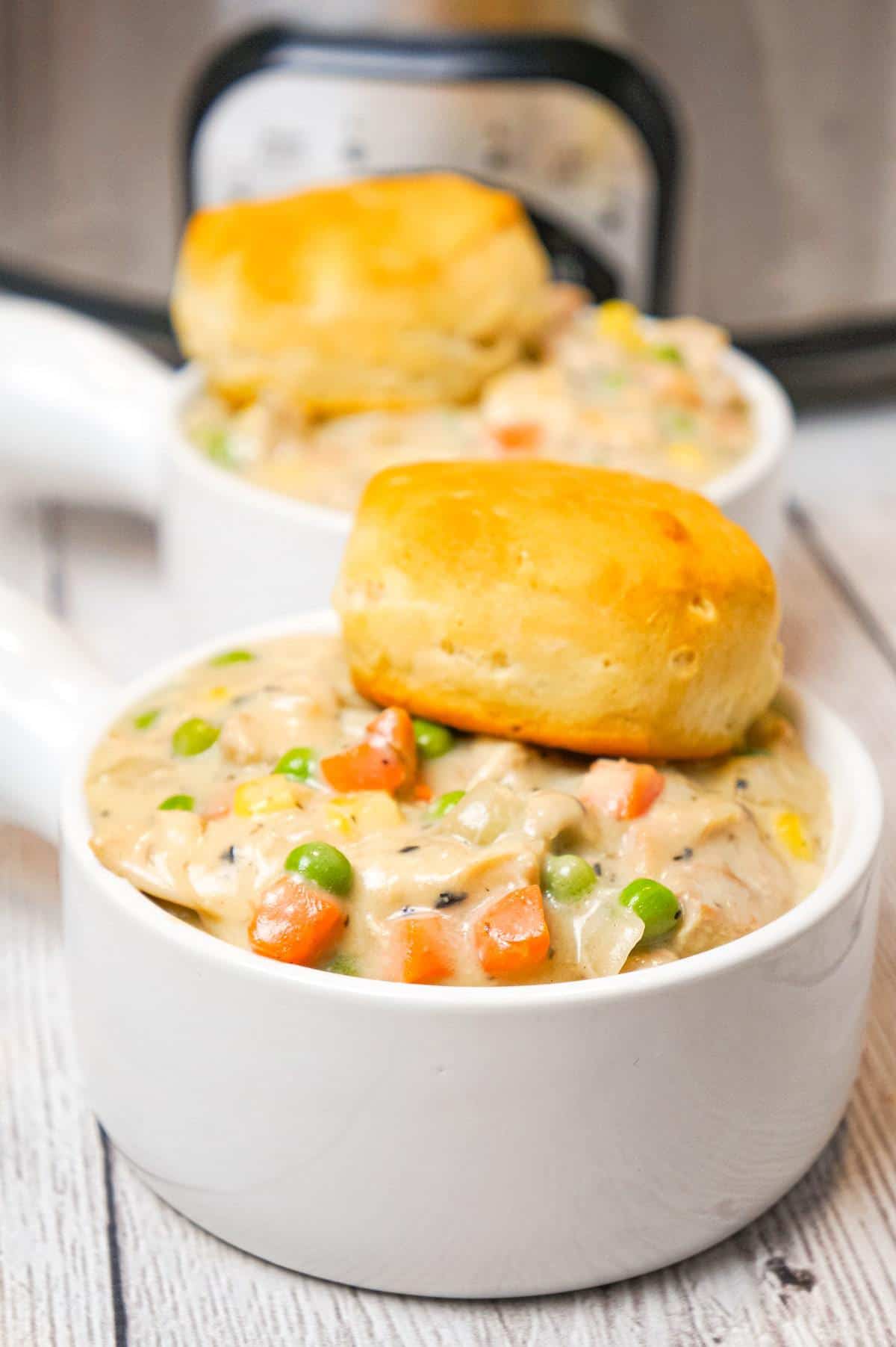 Crock Pot Chicken Pot Pie is an easy slow cooker dinner recipe made with boneless, skinless chicken thighs, cream of mushroom soup, cream of chicken soup and mixed veggies and topped with Pillsbury biscuits.