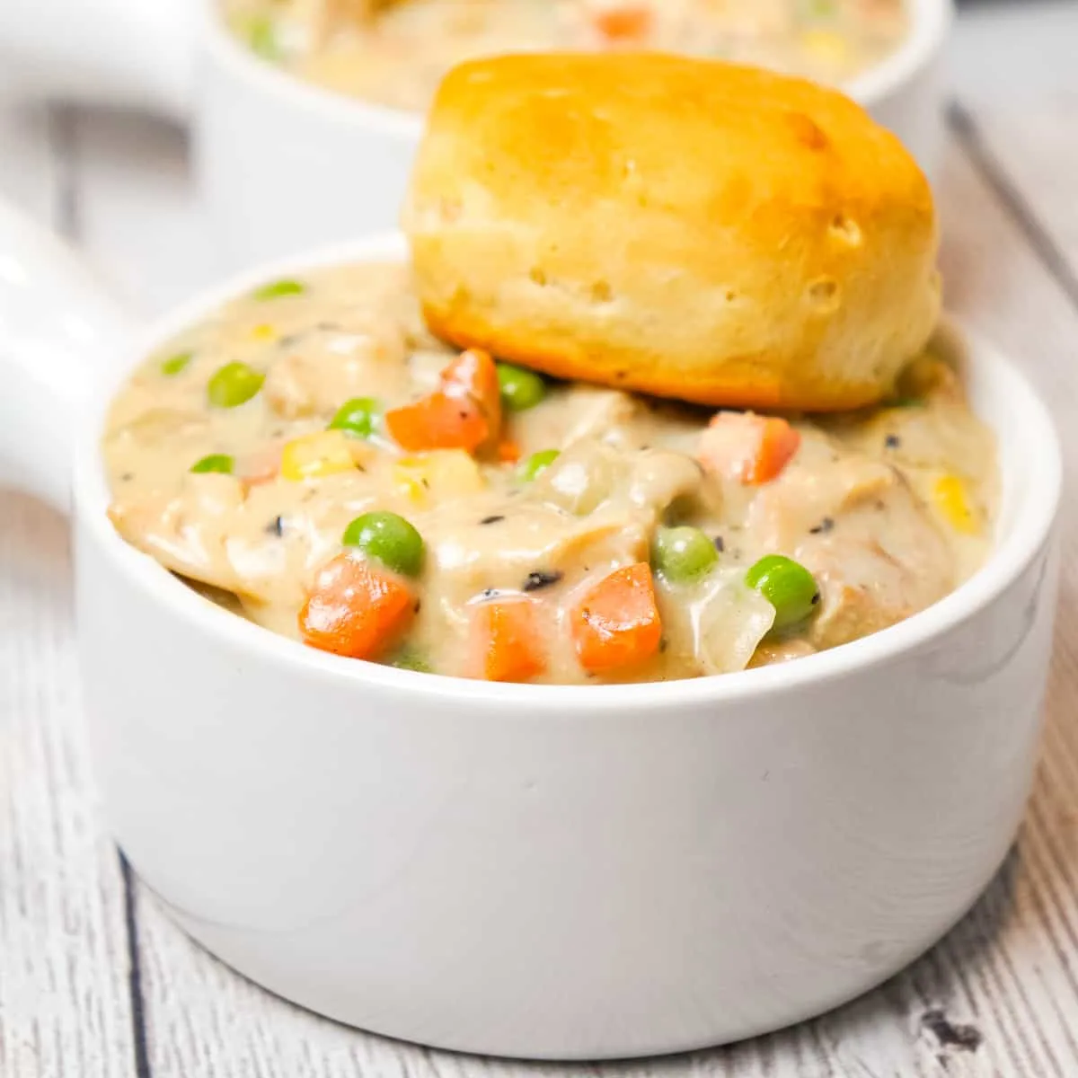 Crock Pot Chicken Pot Pie is an easy slow cooker dinner recipe made with boneless, skinless chicken thighs, cream of mushroom soup, cream of chicken soup and mixed veggies and topped with Pillsbury biscuits.