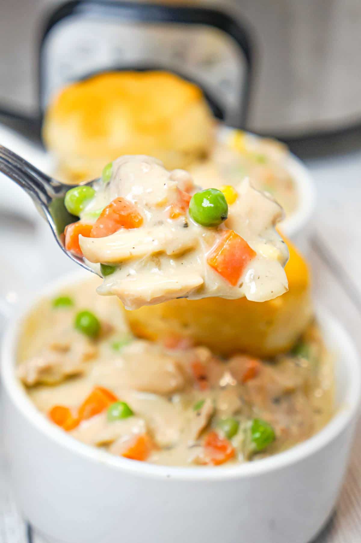 Crock Pot Chicken Pot Pie is an easy slow cooker dinner recipe made with boneless, skinless chicken thighs, cream of mushroom soup, cream of chicken soup and mixed veggies and topped with Pillsbury biscuits.