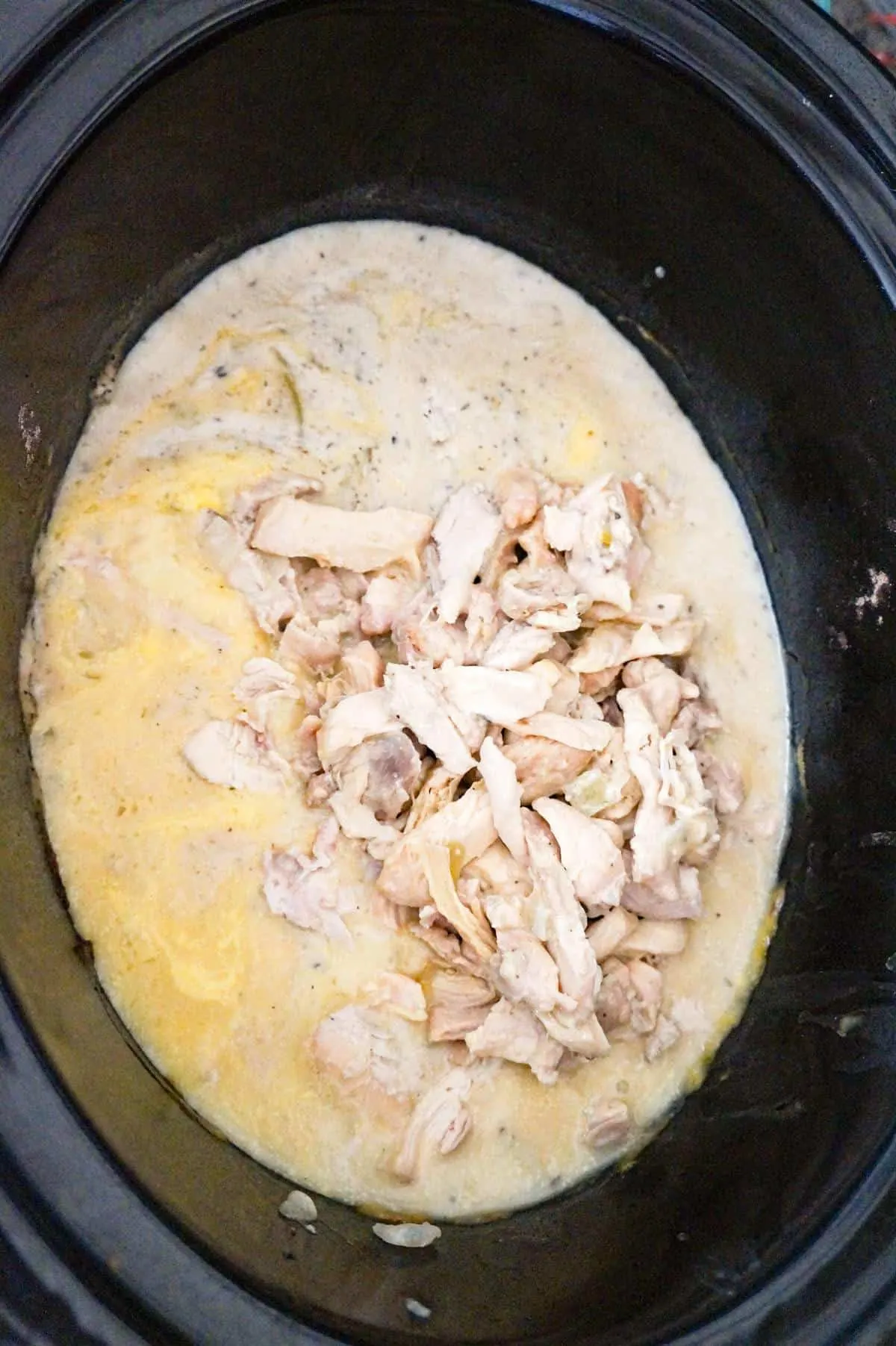 chopped chicken on top of cream soup mixture in a crock pot