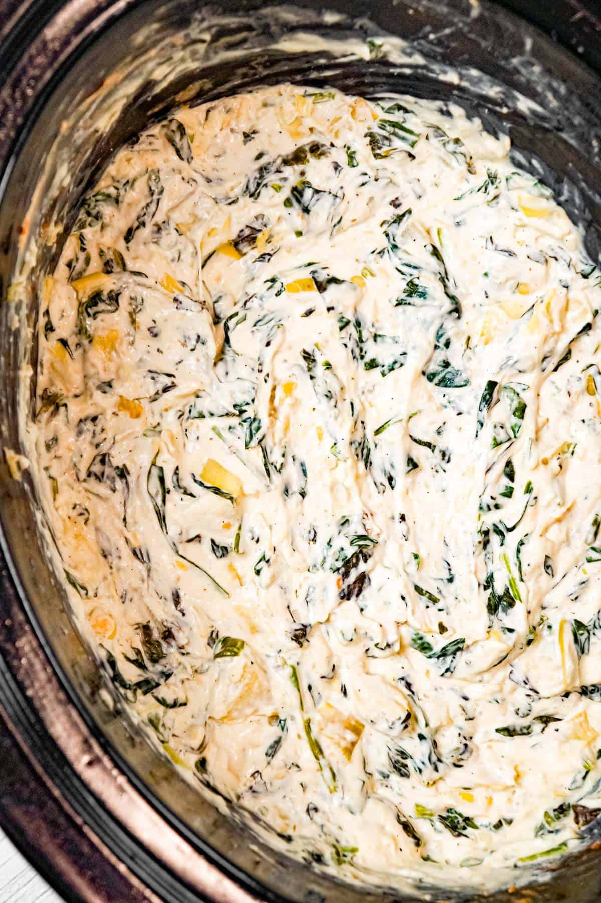 Crock Pot Spinach Artichoke Dip is a delicious hot party dip recipe loaded with baby spinach, chopped artichoke hearts, cream cheese, sour cream, mozzarella and parmesan cheese.