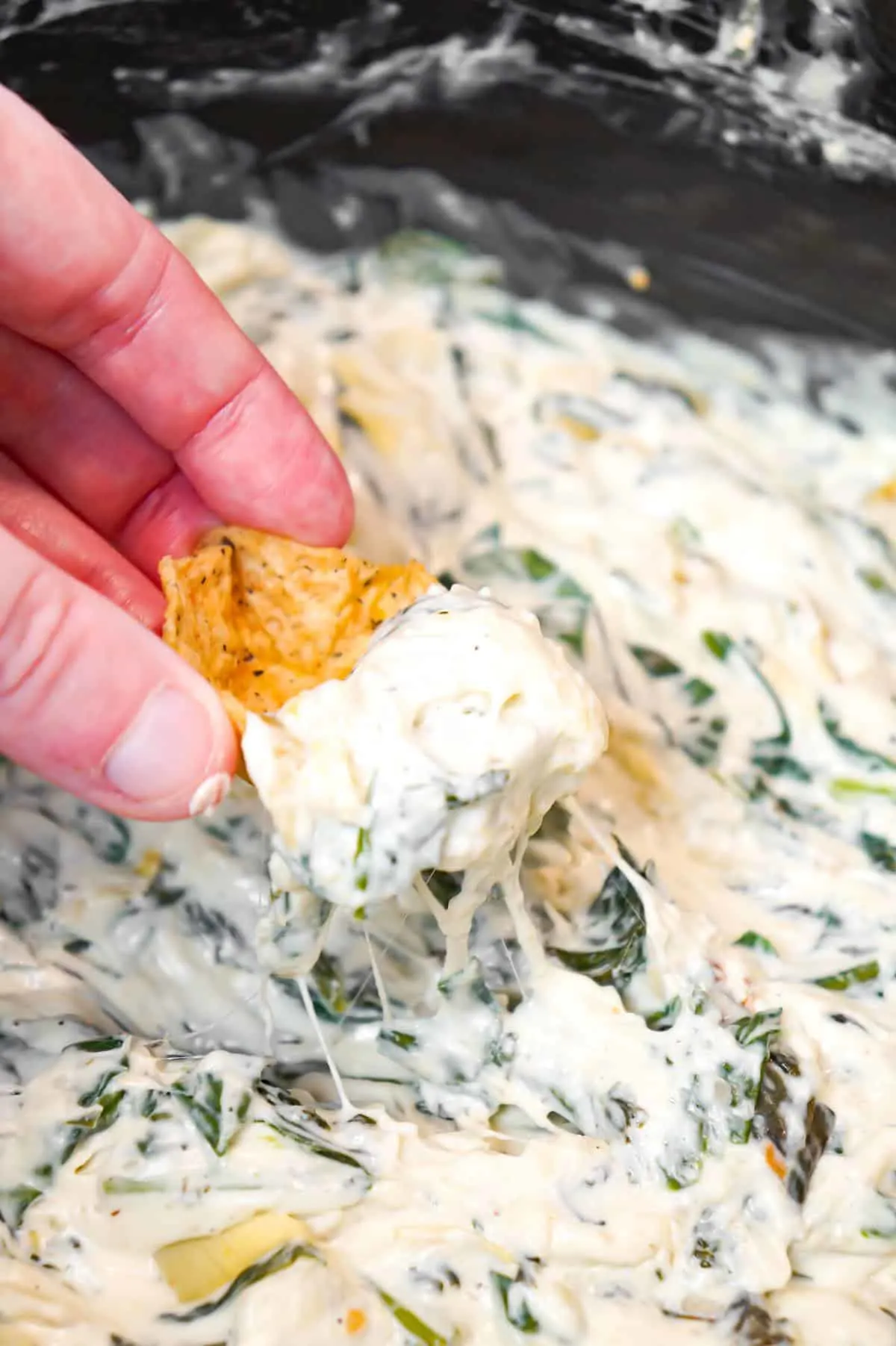 Crock Pot Spinach Artichoke Dip is a delicious hot party dip recipe loaded with baby spinach, chopped artichoke hearts, cream cheese, sour cream, mozzarella and parmesan cheese.