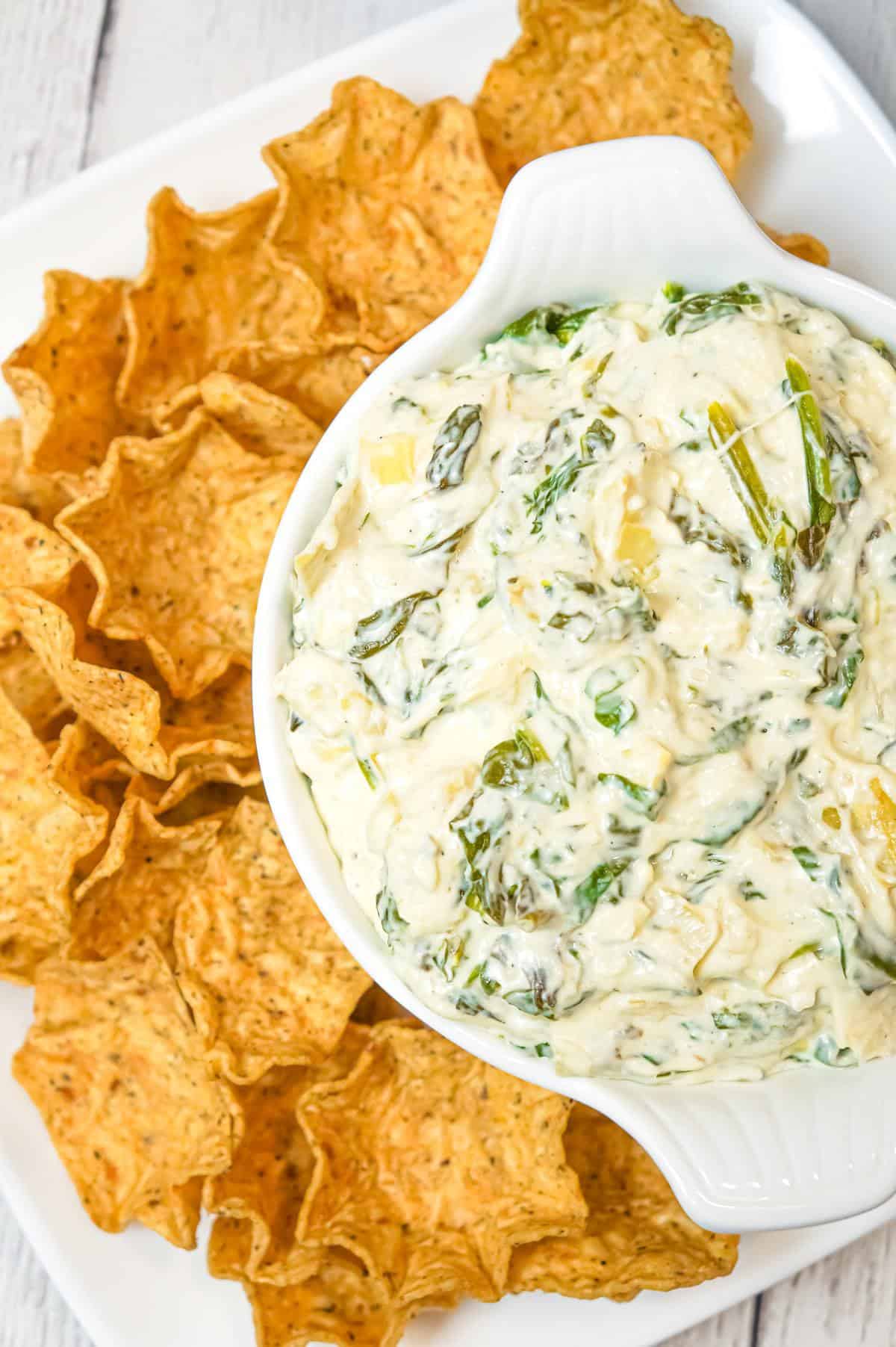 Crock Pot Spinach Artichoke Dip is a delicious hot party dip recipe loaded with baby spinach, chopped artichoke hearts, cream cheese, sour cream, mozzarella and parmesan cheese.