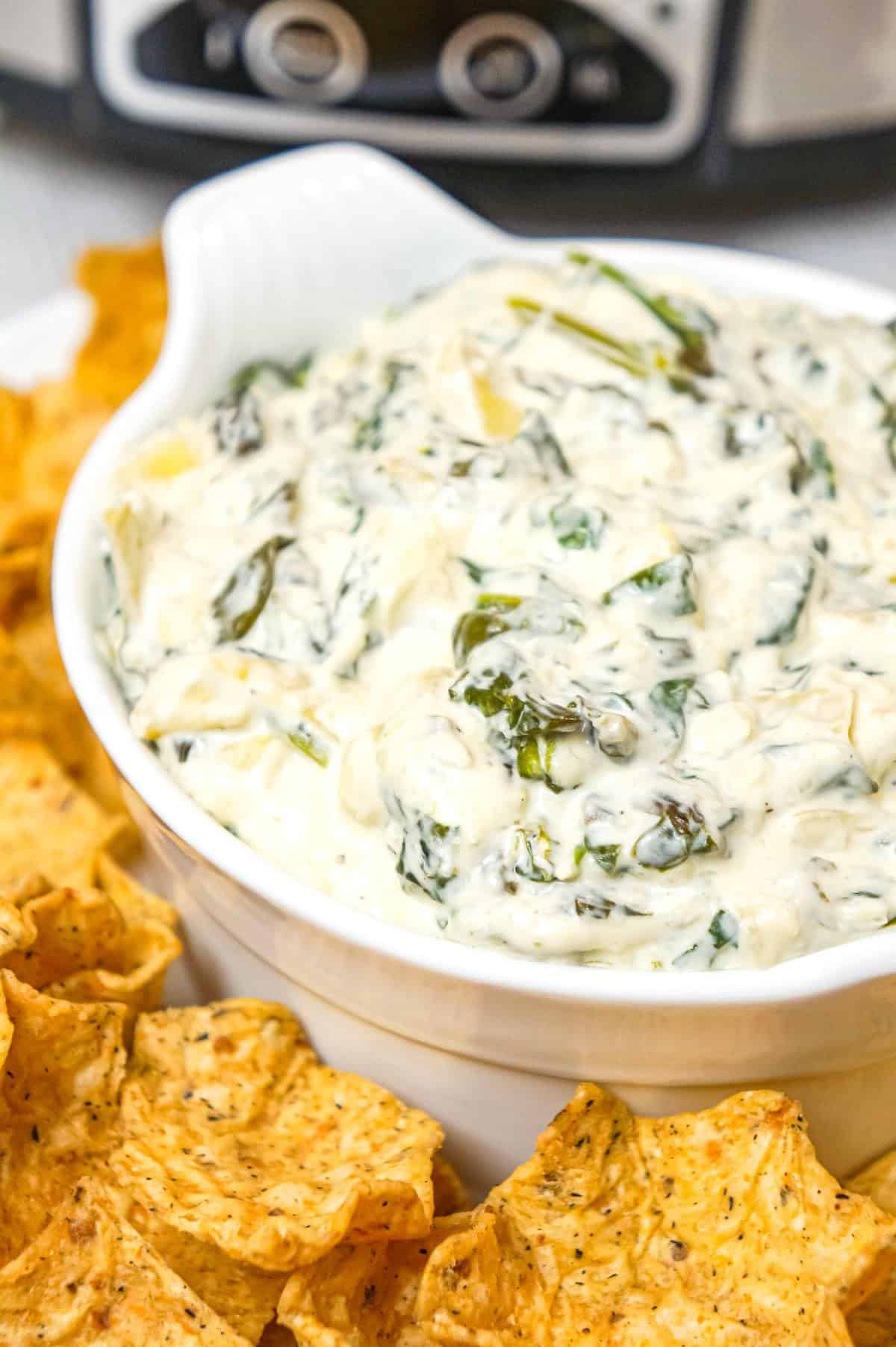 Crock Pot Spinach Artichoke Dip is a delicious hot party dip recipe loaded with baby spinach, chopped artichoke hearts, cream cheese, sour cream, mozzarella and parmesan cheese.