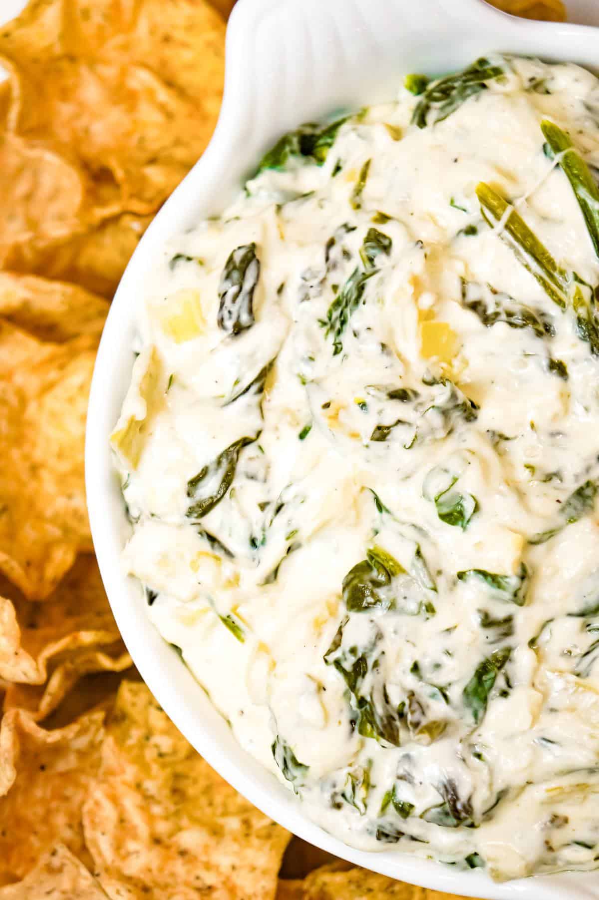 Crock Pot Spinach Artichoke Dip is a delicious hot party dip recipe loaded with baby spinach, chopped artichoke hearts, cream cheese, sour cream, mozzarella and parmesan cheese.