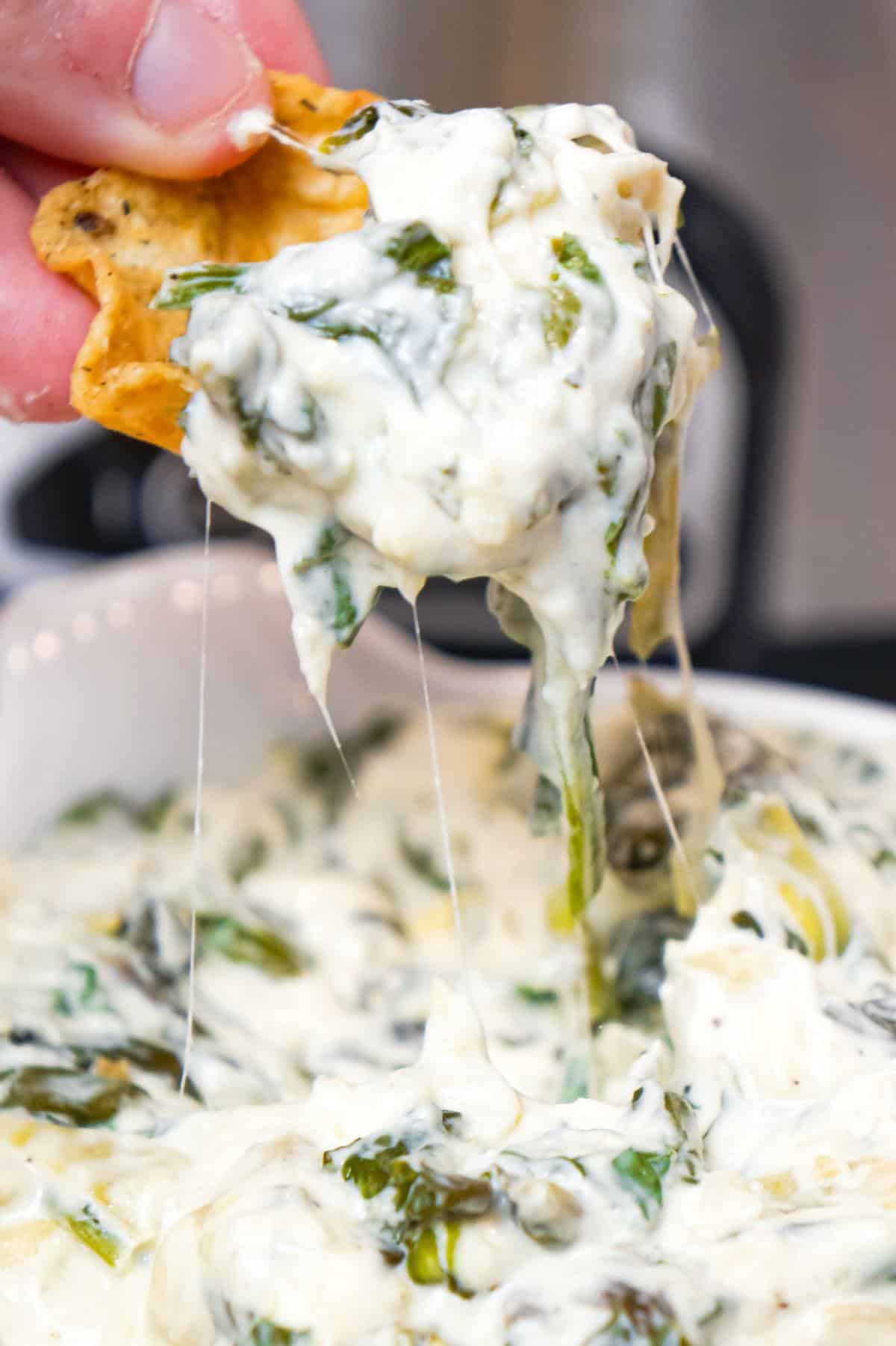 Crock Pot Spinach Artichoke Dip is a delicious hot party dip recipe loaded with baby spinach, chopped artichoke hearts, cream cheese, sour cream, mozzarella and parmesan cheese.