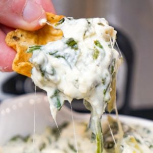 Crock Pot Spinach Artichoke Dip is a delicious hot party dip recipe loaded with baby spinach, chopped artichoke hearts, cream cheese, sour cream, mozzarella and parmesan cheese.