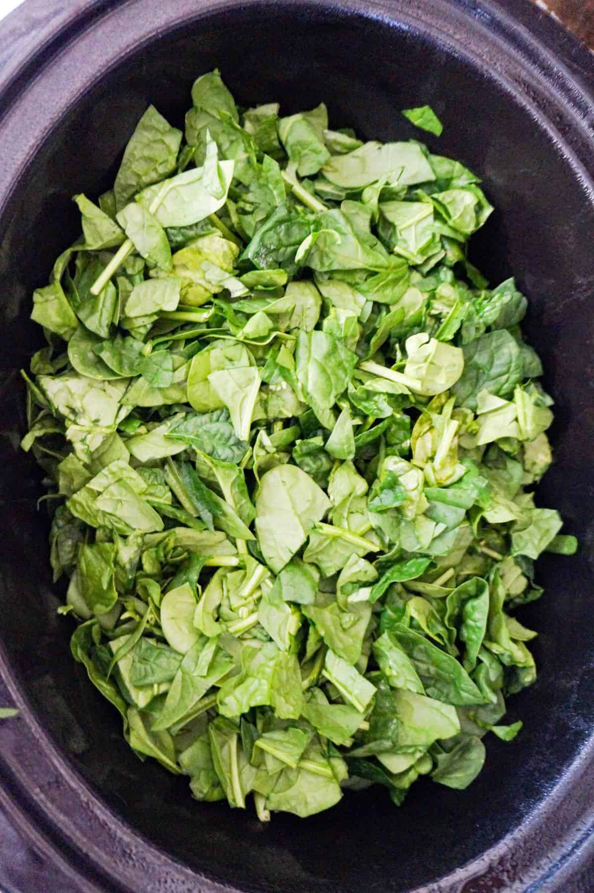 chopped spinach in a slow cooker