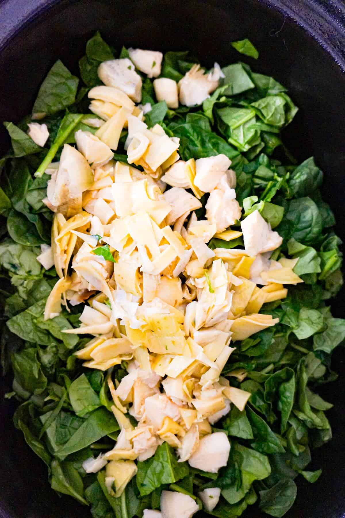 chopped artichoke and chopped spinach in a crock pot