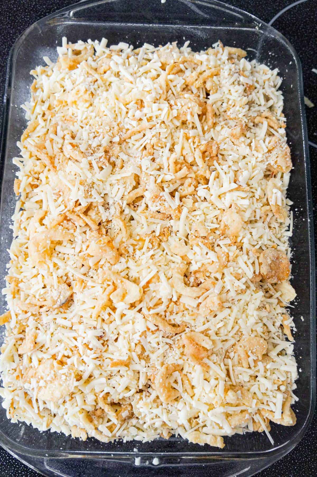 shredded cheese and crispy fried onions on top of chicken casserole