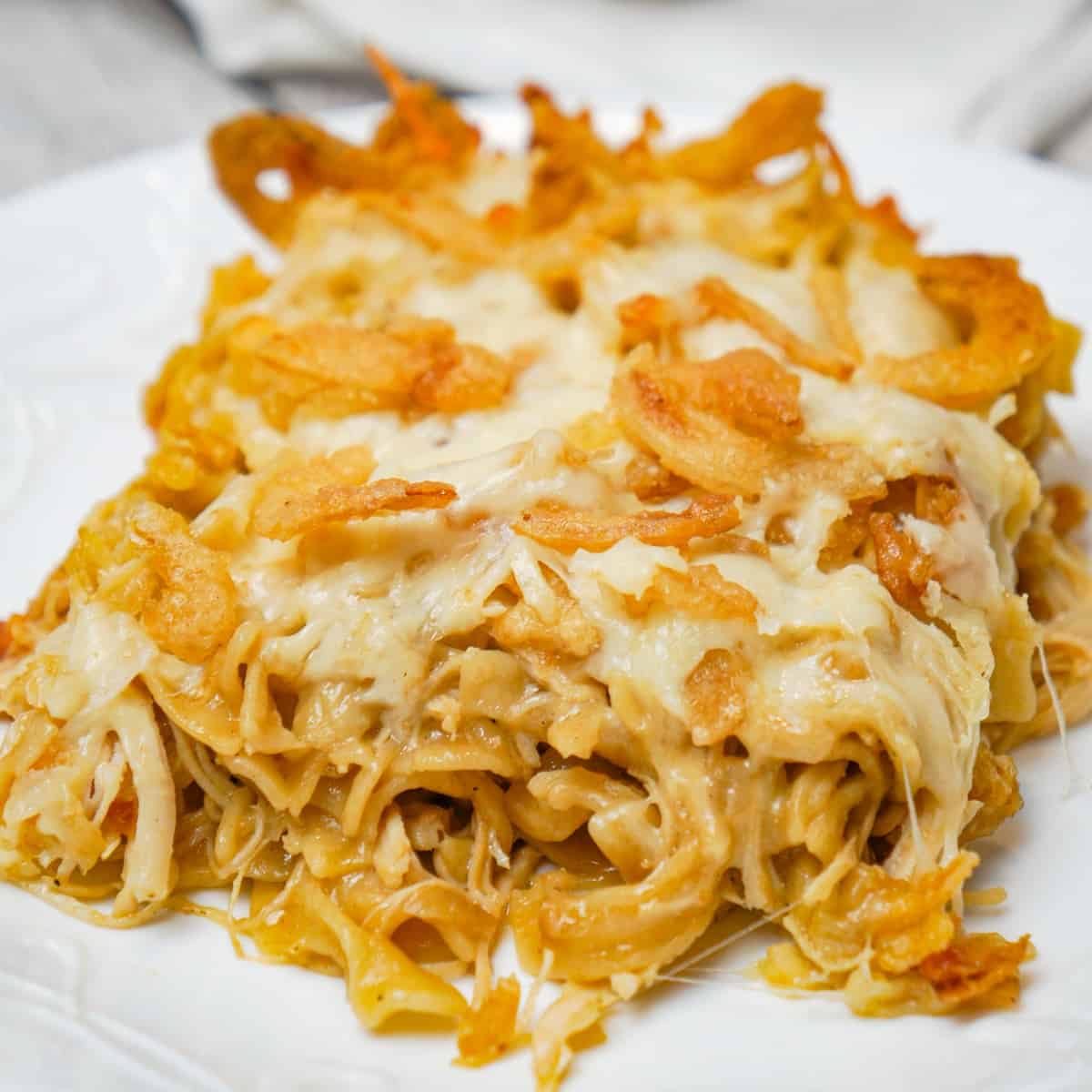 French Onion Chicken Casserole is a hearty casserole recipe loaded with shredded chicken, egg noodles, onion soup mix, cream of chicken soup, mozzarella cheese, parmesan cheese and French's crispy fried onions.
