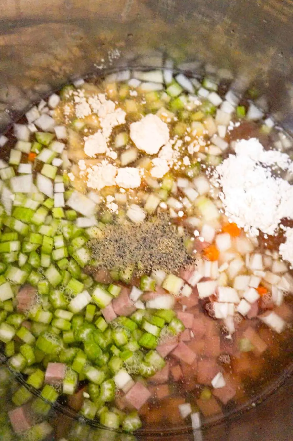 spices on top of diced vegetables and broth in Instant Pot