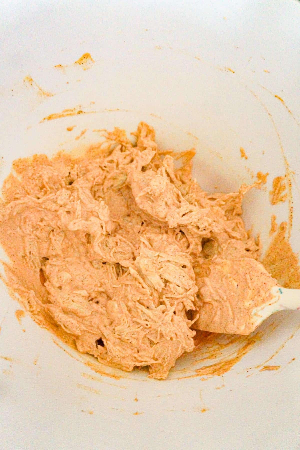shredded chicken and sour cream mixture in a mixing bowl