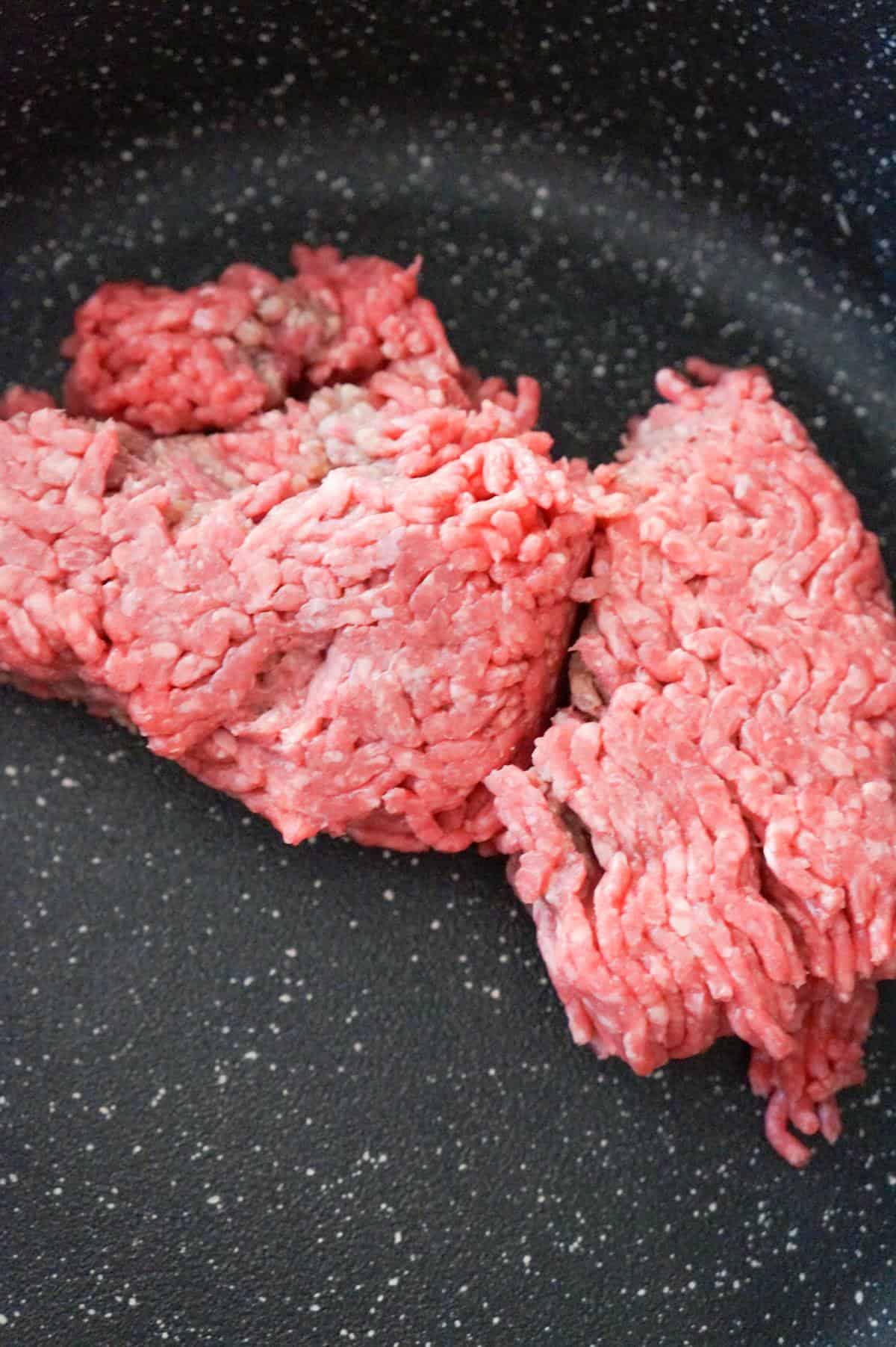 raw ground beef in a saute pan