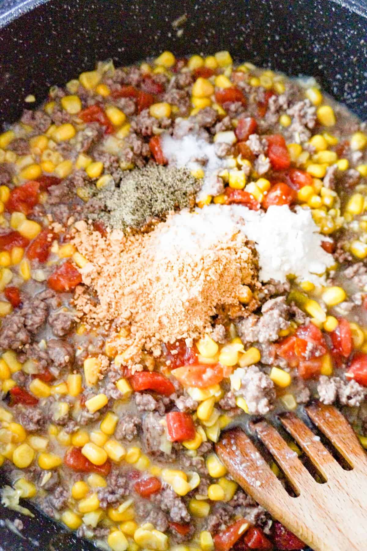 spices on top of ground beef mixture in a saute pan