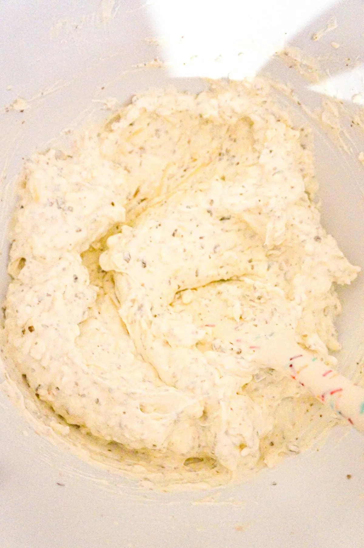 cream cheese, sour cream and basil pesto mixture in a baking dish