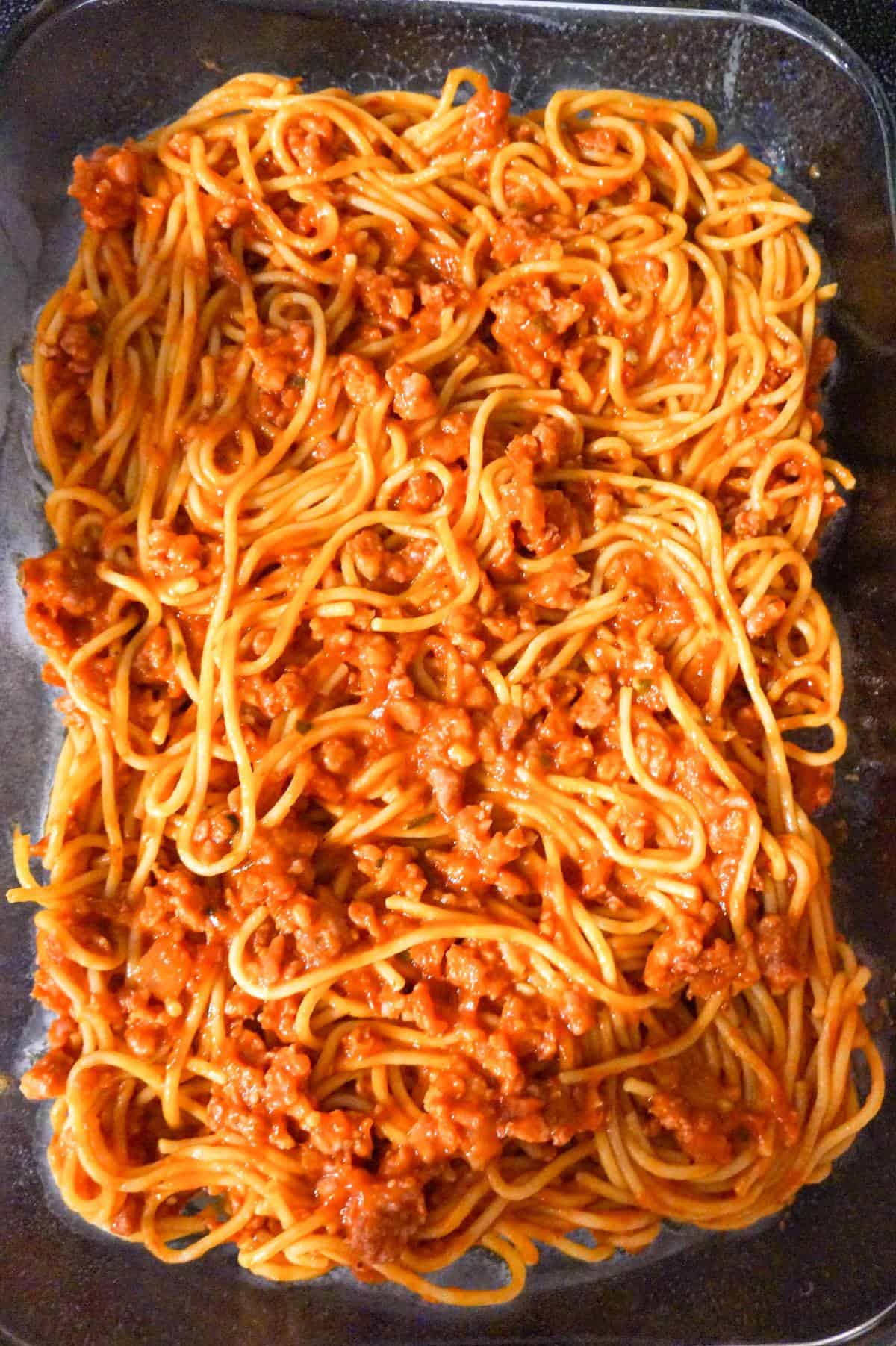 spaghetti and ground sausage tossed in marinara in a baking dish