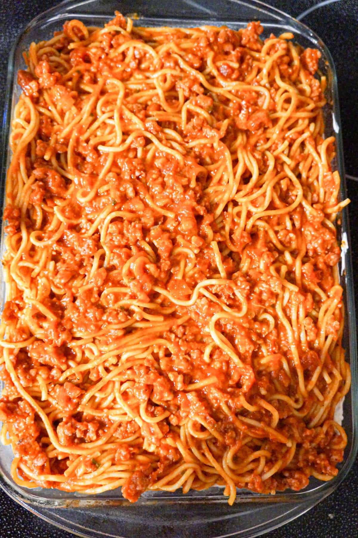 spaghetti, marina and ground sausage mixture in a baking dish