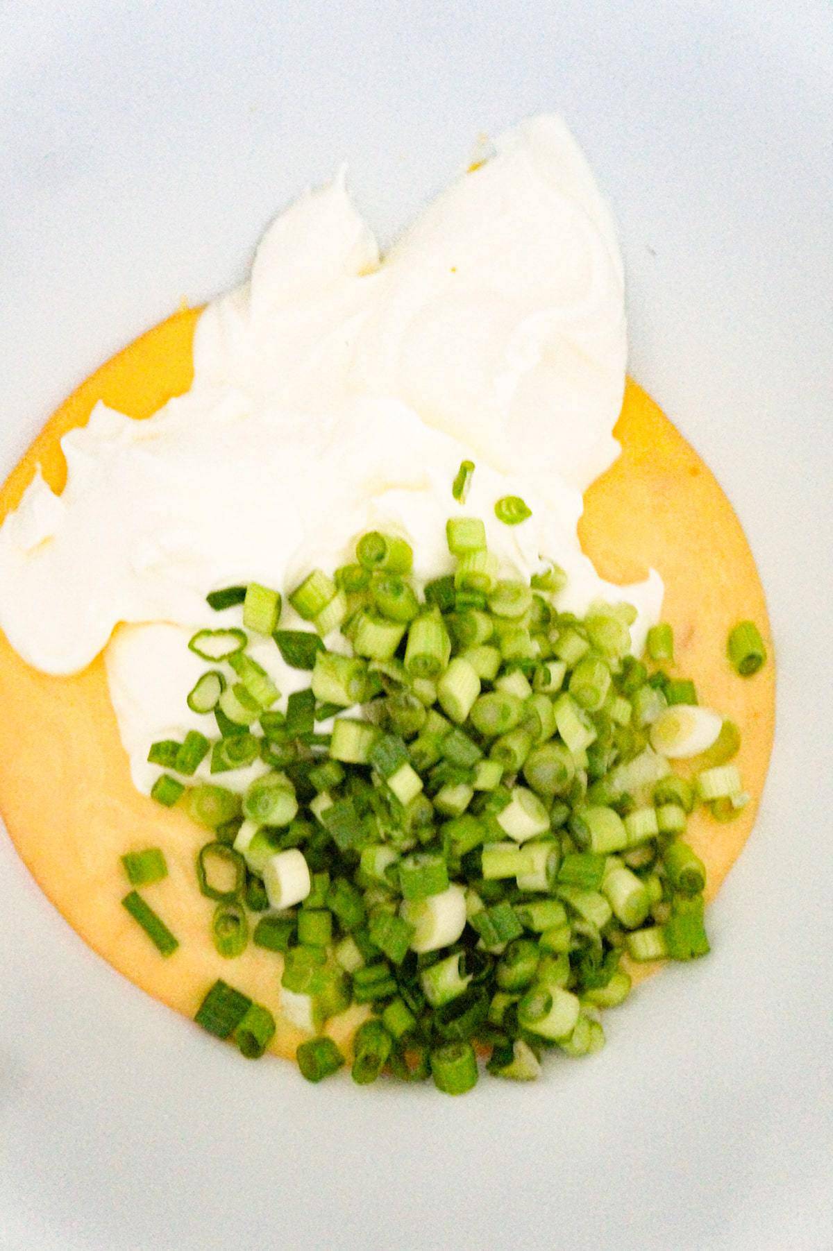 chopped green onions, sour cream and cream of chicken soup in a mixing bowl