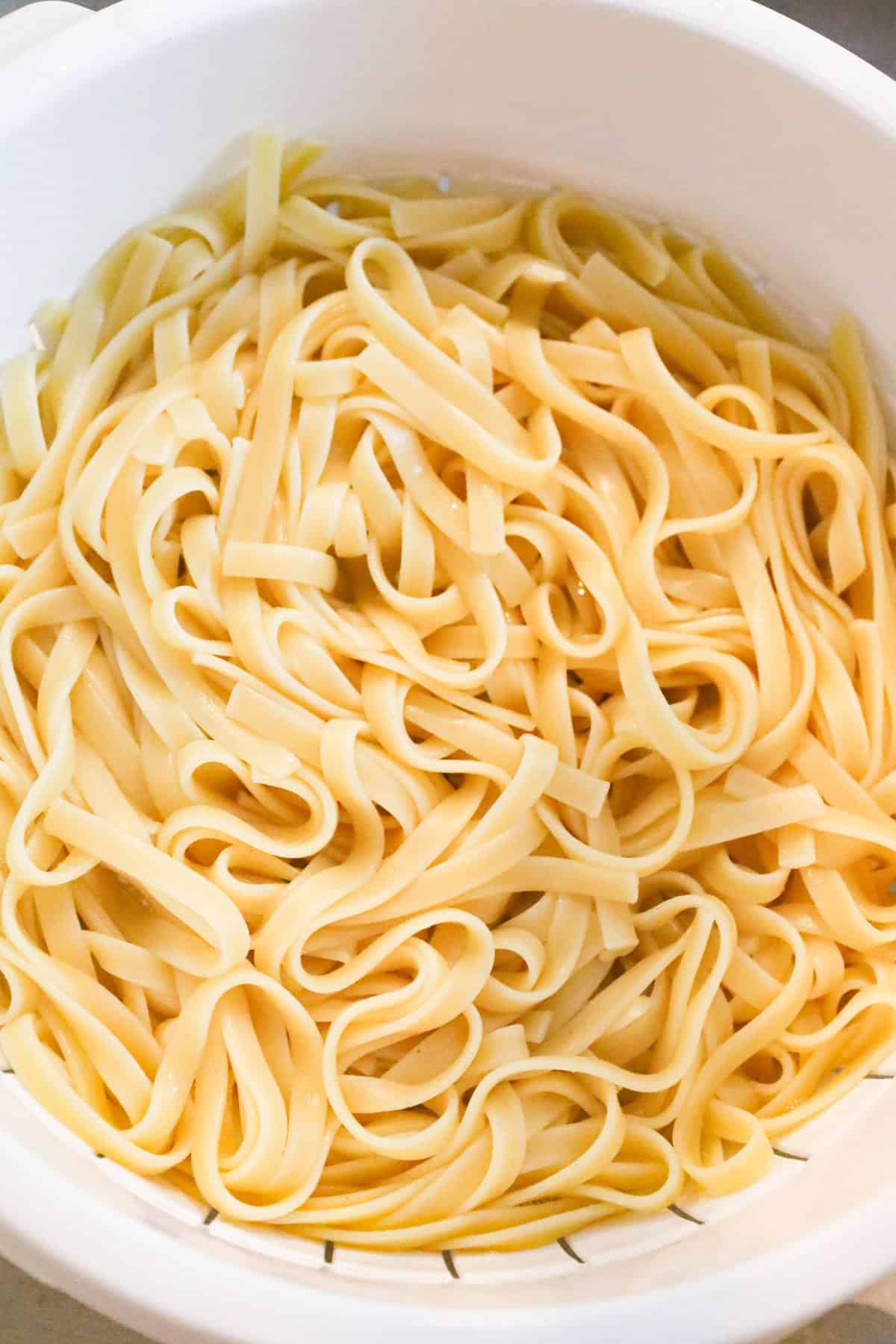 cooked fettuccine noodles in a colander